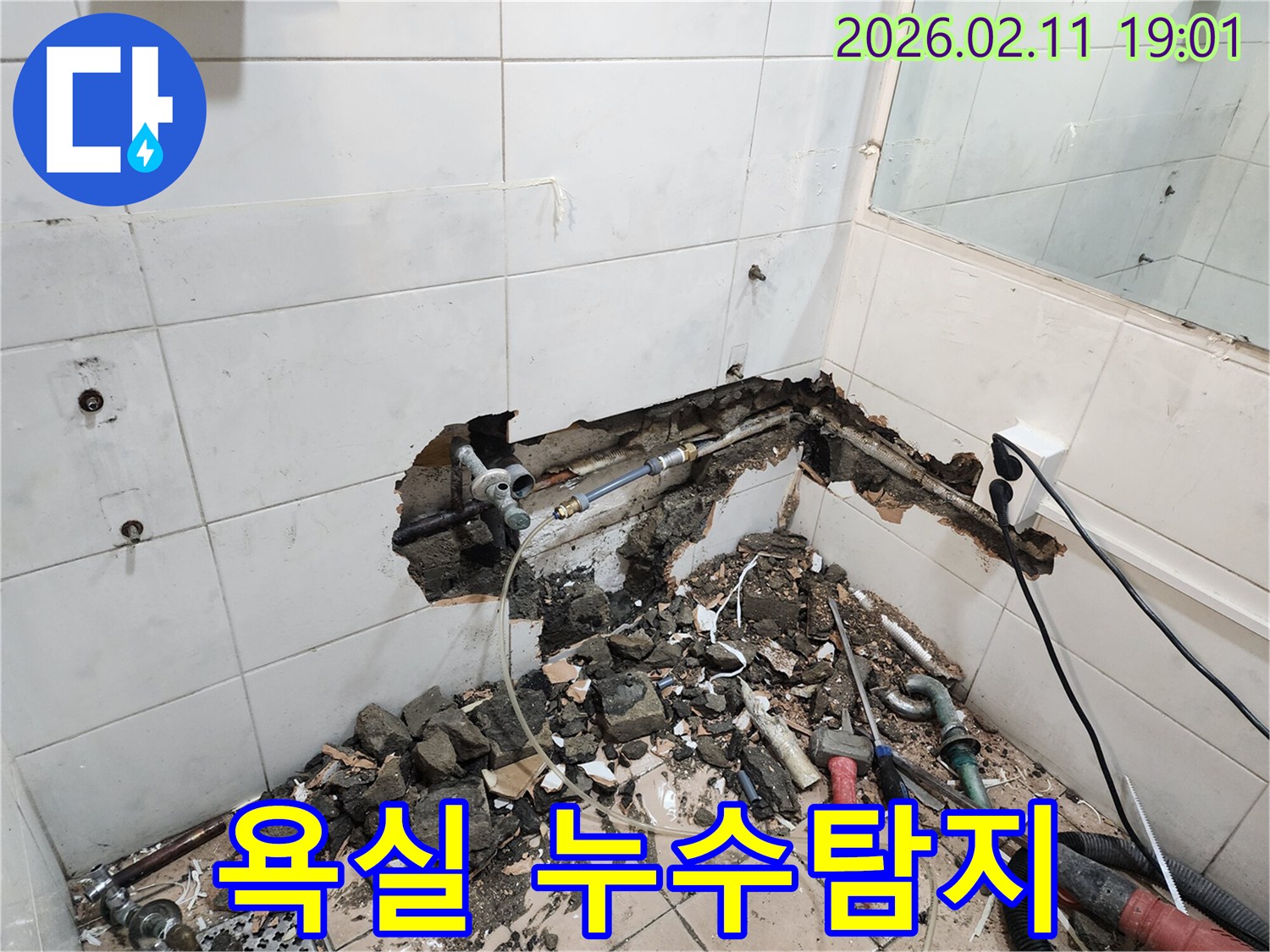 아파트 욕실의-누수 문제를 해결하기 위해-벽면을 파쇄하고-배관을 점검하는-전문가의-작업 현장입니다.