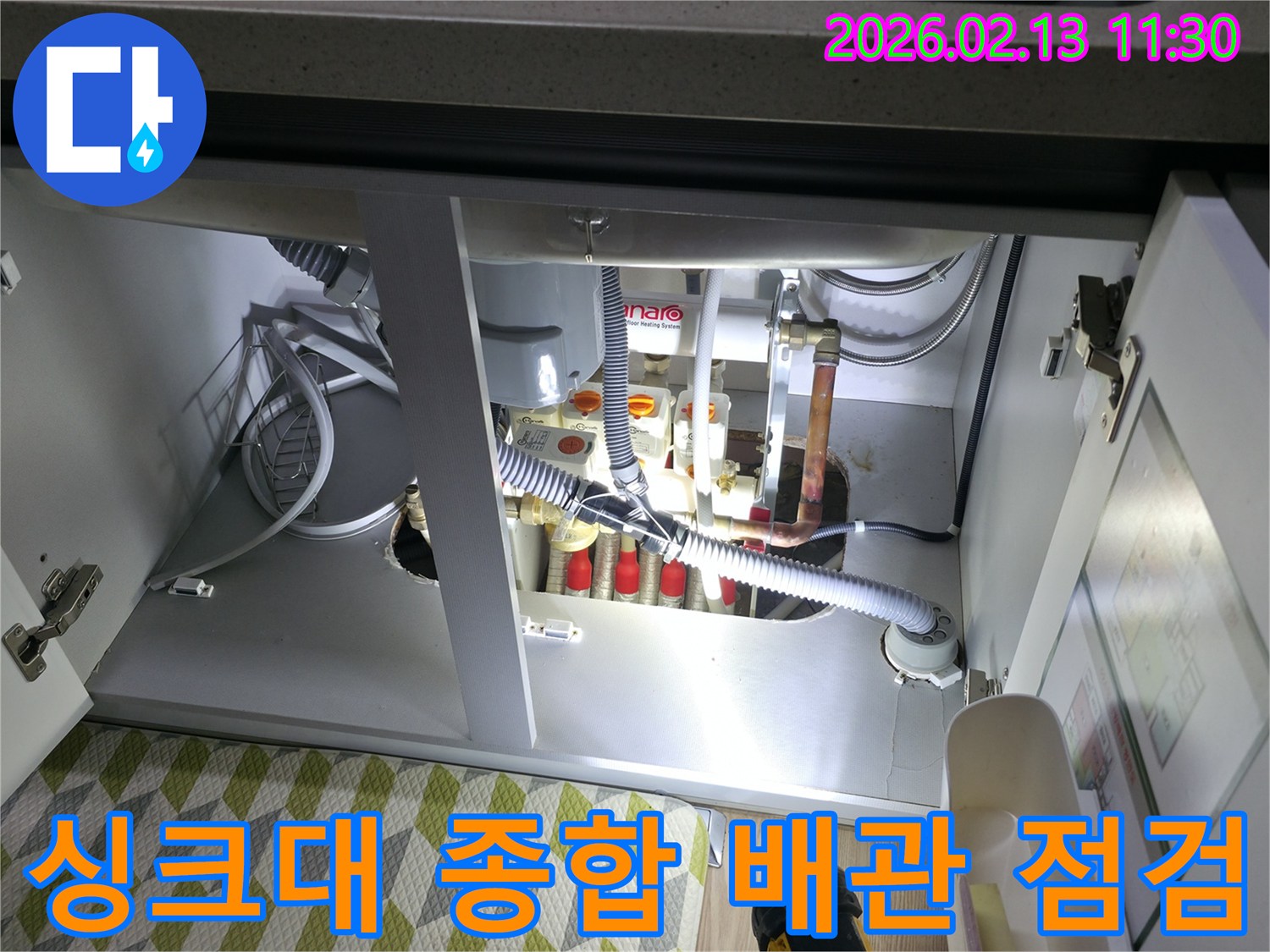 싱크대 하부의 모든 배관을-종합적으로 점검하여-누수 및 잠재적 문제점을-파악하는 전문가의 모습