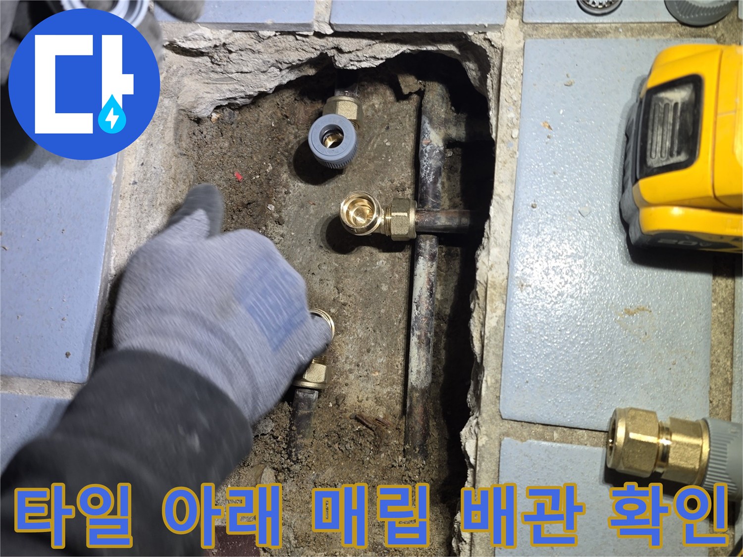 바닥 타일을 제거하고 드러난 훼손된 배관과 작업 도구