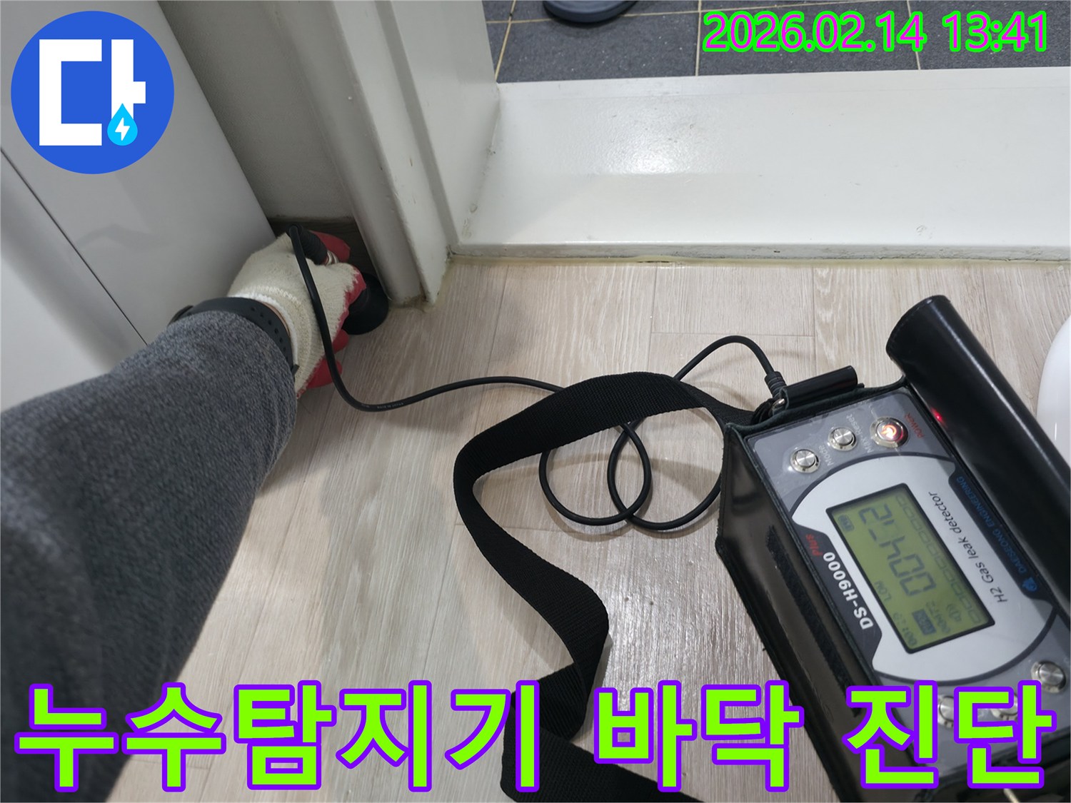 전문 누수 탐지 장비를-바닥과 벽면 경계에 대고-누수 지점을 정밀하게 탐지하는-엔지니어의 모습입니다.