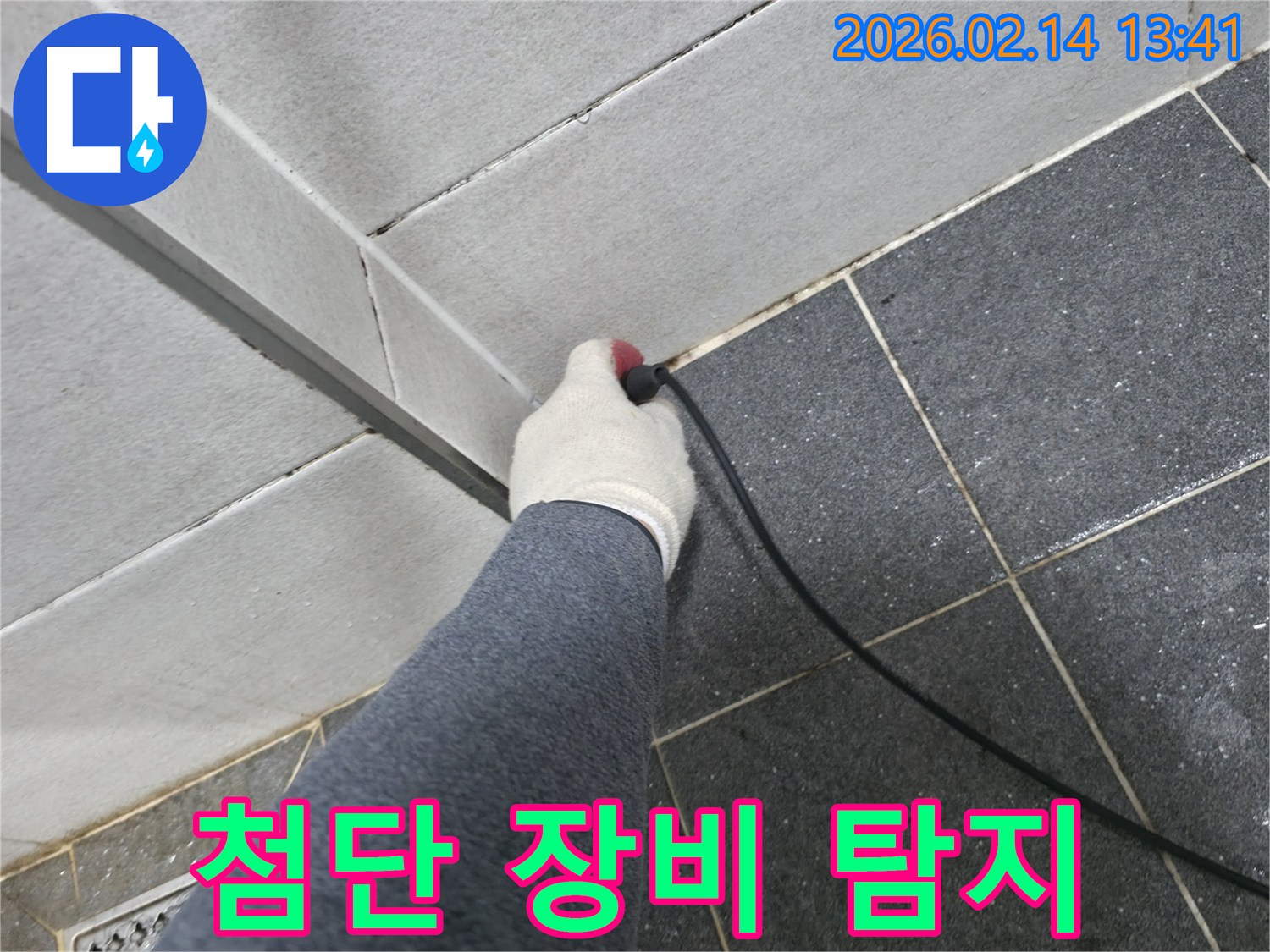 전문 엔지니어가-하얀 장갑을 끼고-첨단 누수 탐지 장비로-타일 틈새의-미세한 물방울까지 감지하는 모습입니다.