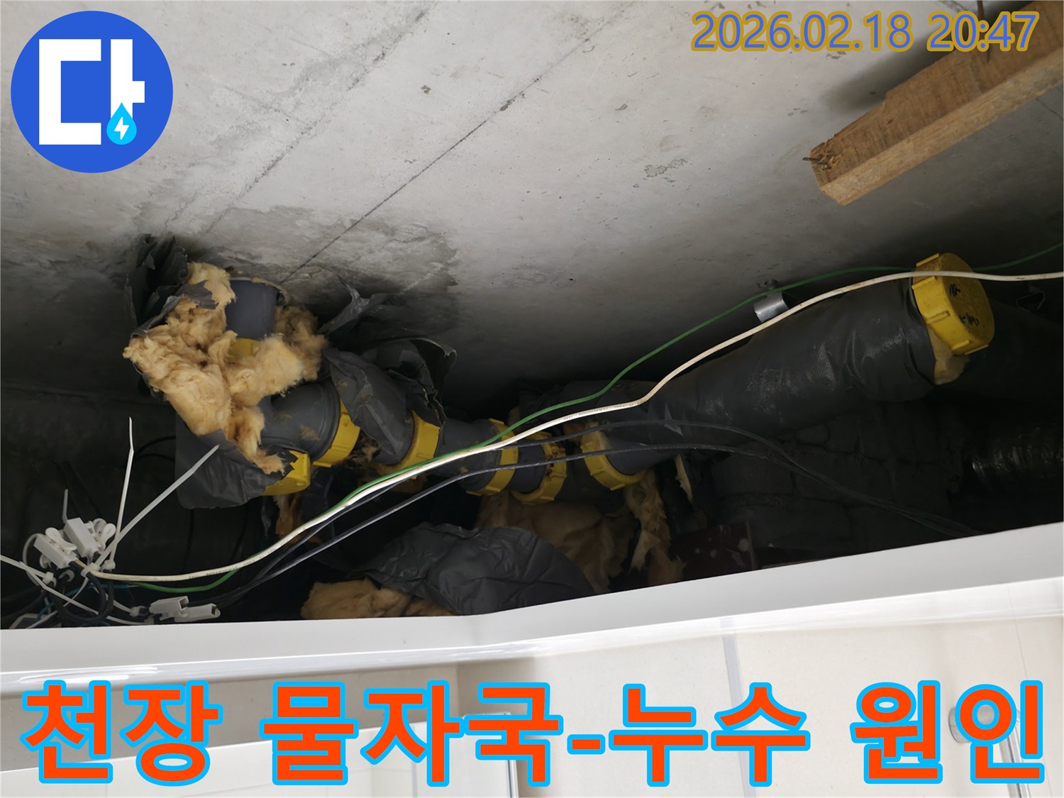 천장 속에서-누수 흔적과 함께-노출된 배관 및-손상된 단열재입니다.