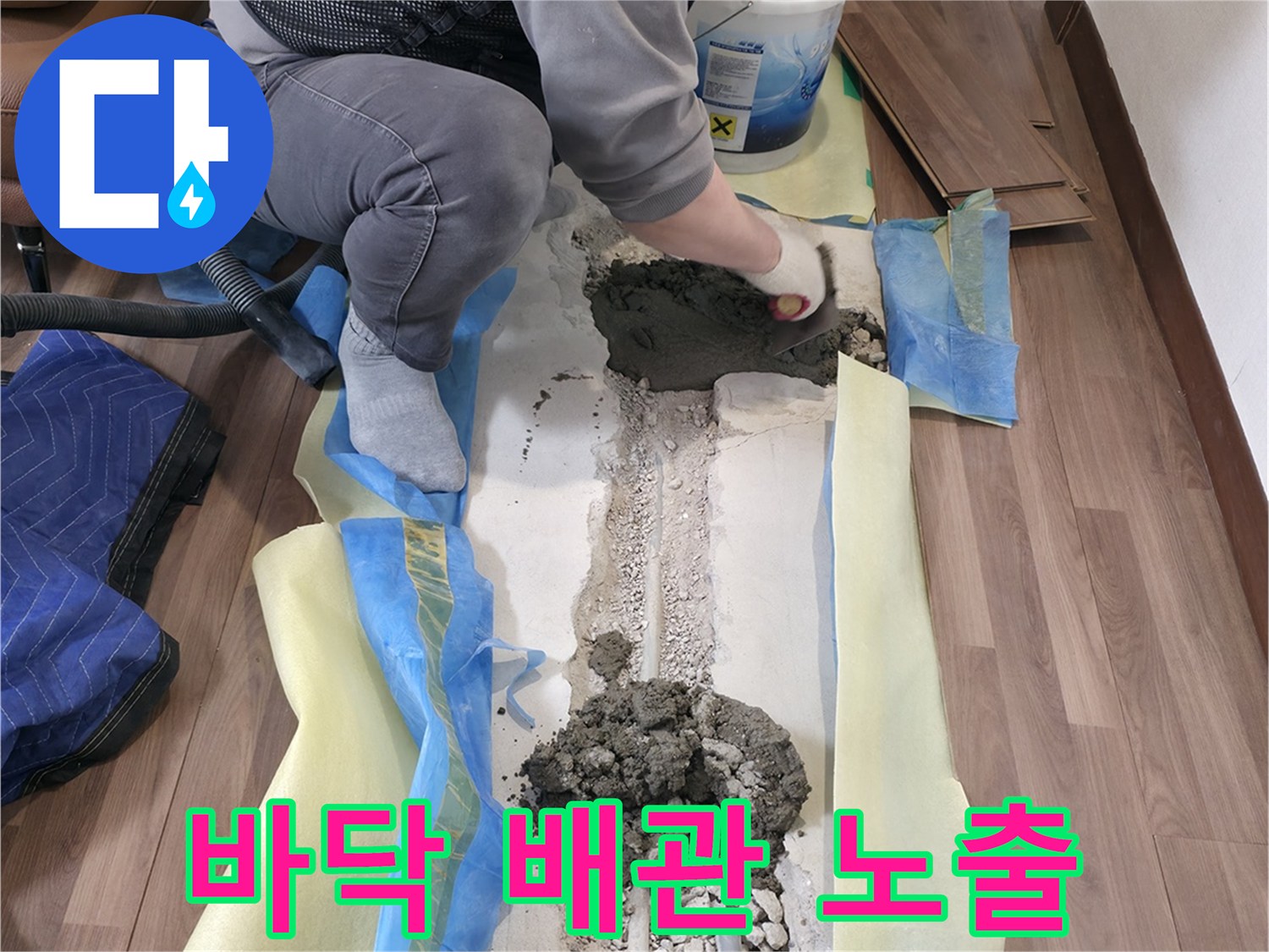 거실 마루를 탈거한 후 드러난 굴착 부위와 노출된 수도 배관