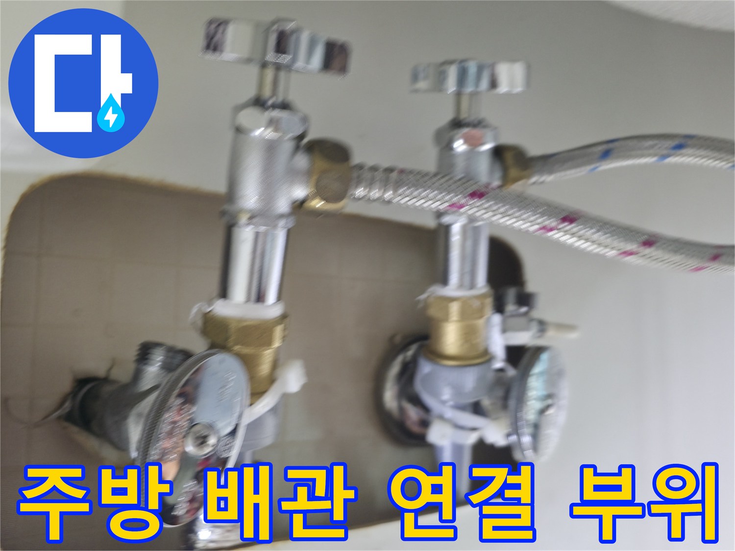 싱크대 하부의 은색 주름관과 수도 밸브 연결 상태를 보여주는 사진입니다.