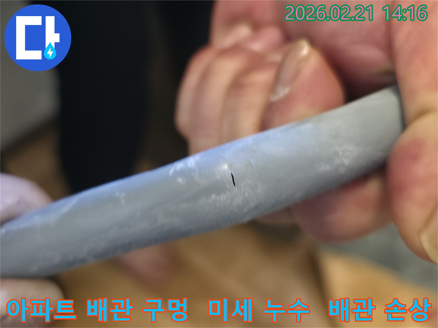 아파트 배관에 발생한 아주 작은 구멍을-확대하여-보여주며-누수의 심각성을-시각적으로-전달하는-이미지입니다.