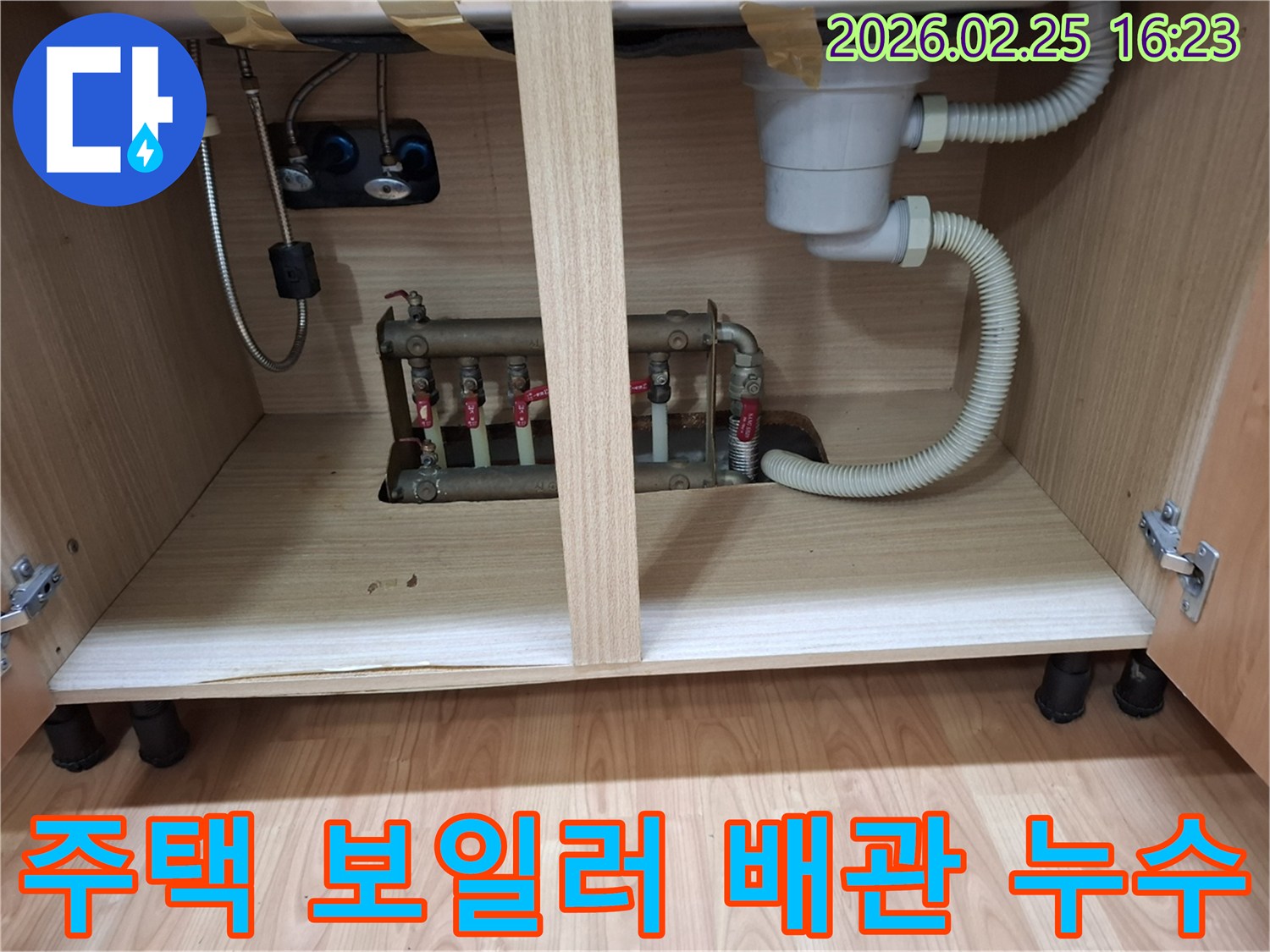 주택 싱크대 하부장 내부에 위치한 보일러 배관에서 물이 새는 현장 사진입니다