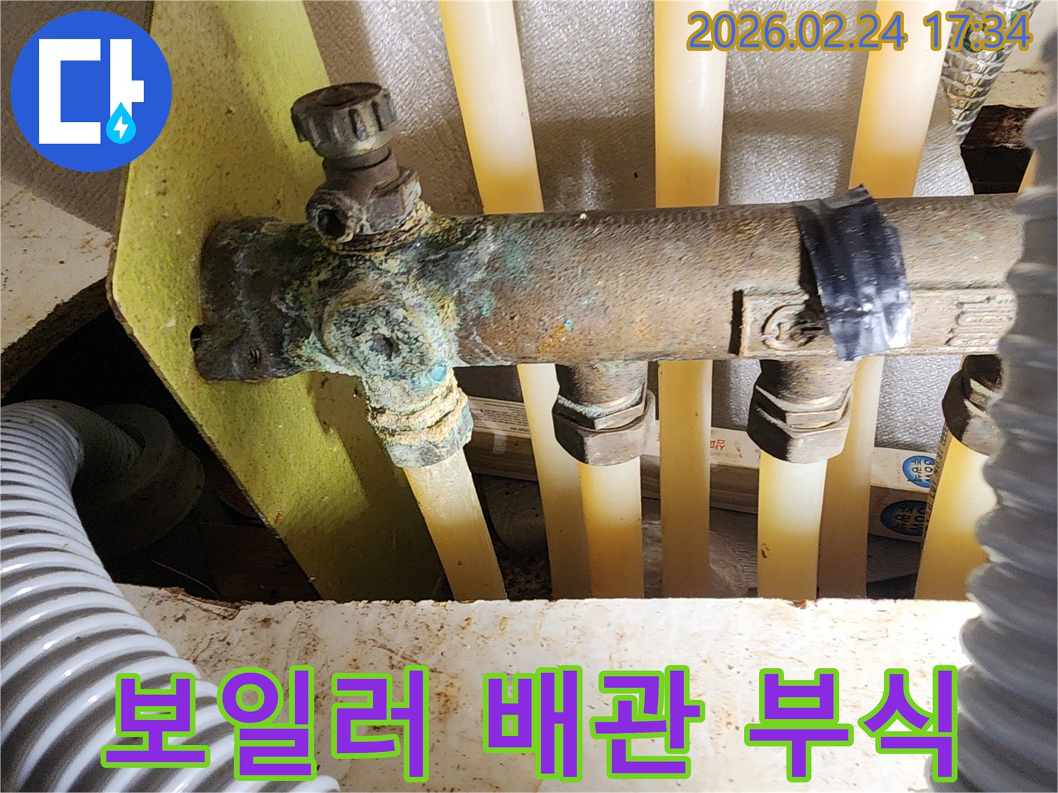 이 이미지는 아파트 보일러 배관 분배기의 배관에서-발생한 심각한 부식과-그로 인한 누수 현장을 보여주며-정밀 진단을 통한 해결이 시급함을 나타냅니다.