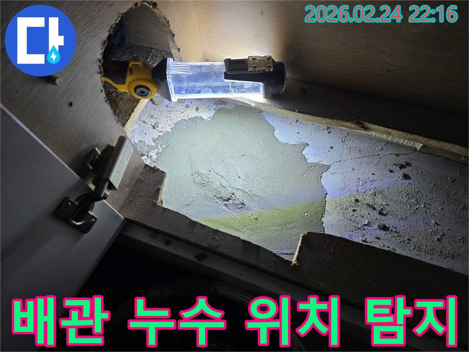 누수-엔지니어가-어두운-싱크대-하부에서-배관-누수-위치를-정확히-찾기-위해-조명-장비를-활용하는-현장