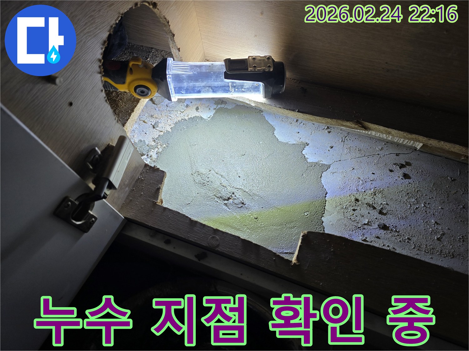 누수-엔지니어가-어둡고-좁은-싱크대-하부에서-누수-지점을-확인하기-위해-조명-장비를-사용하여-탐지하는-모습