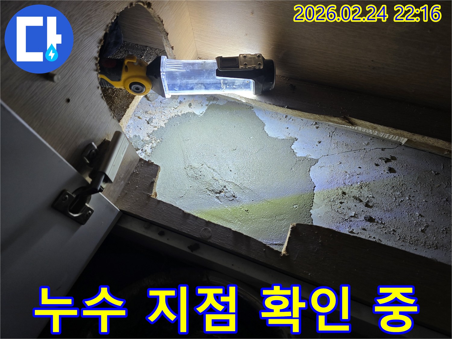 누수-엔지니어가-어둡고-좁은-싱크대-하부에서-누수-지점을-확인하기-위해-조명-장비를-사용하여-탐지하는-모습