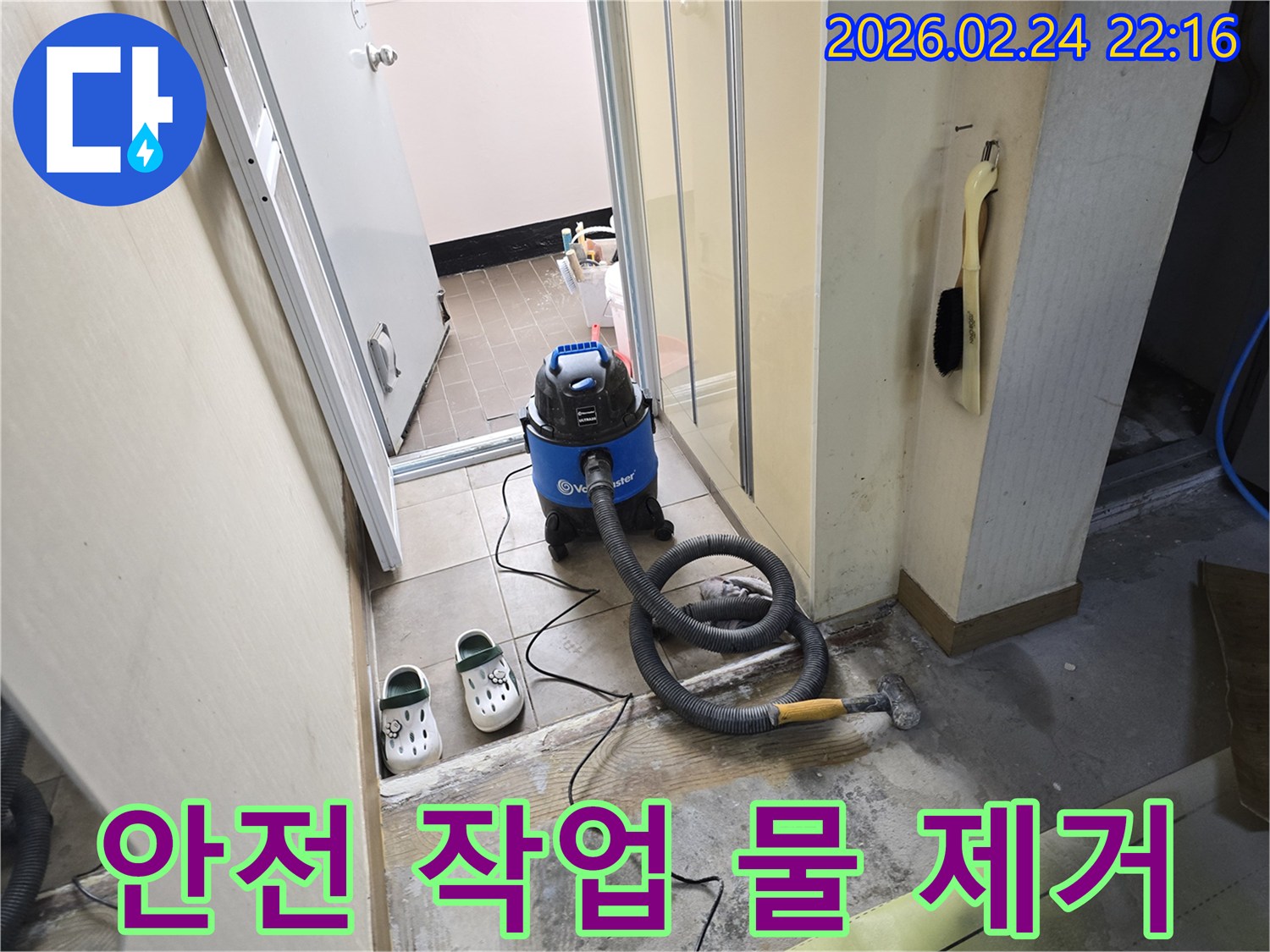 누수 현장에서-작업자의 안전을 위해-습식 청소기로-바닥의 물기를-제거하는 모습