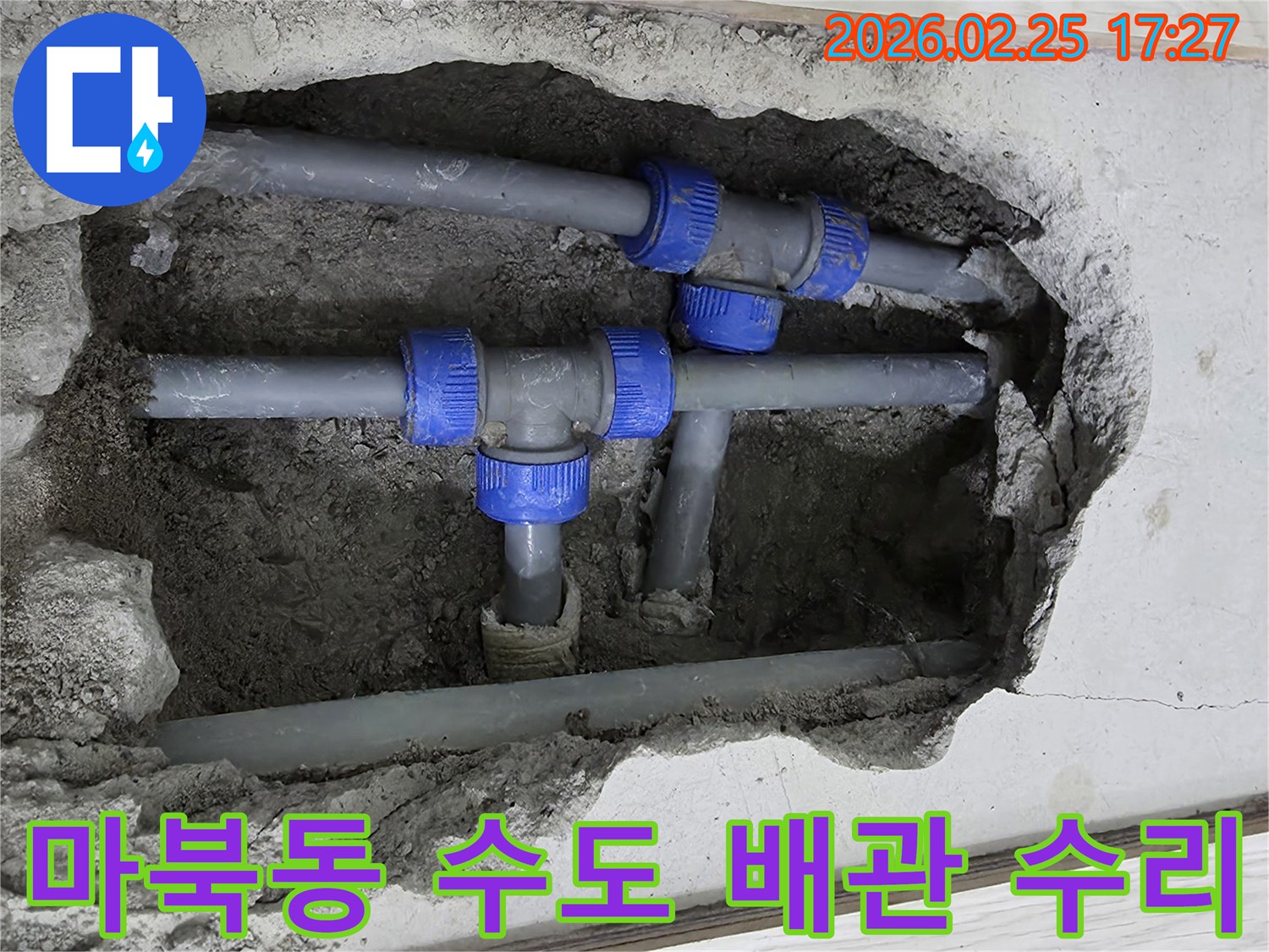 콘크리트 바닥을 깨고 드러난-파란색 연결 부속이 있는 회색 수도 배관-누수 지점을 전문가가 수리하는 현장