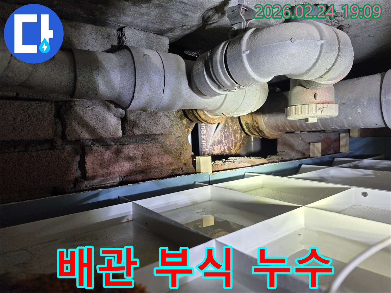 오래된-배관의-부식으로-인해-물이-새어-나와-고이는-현장을-촬영한-이미지