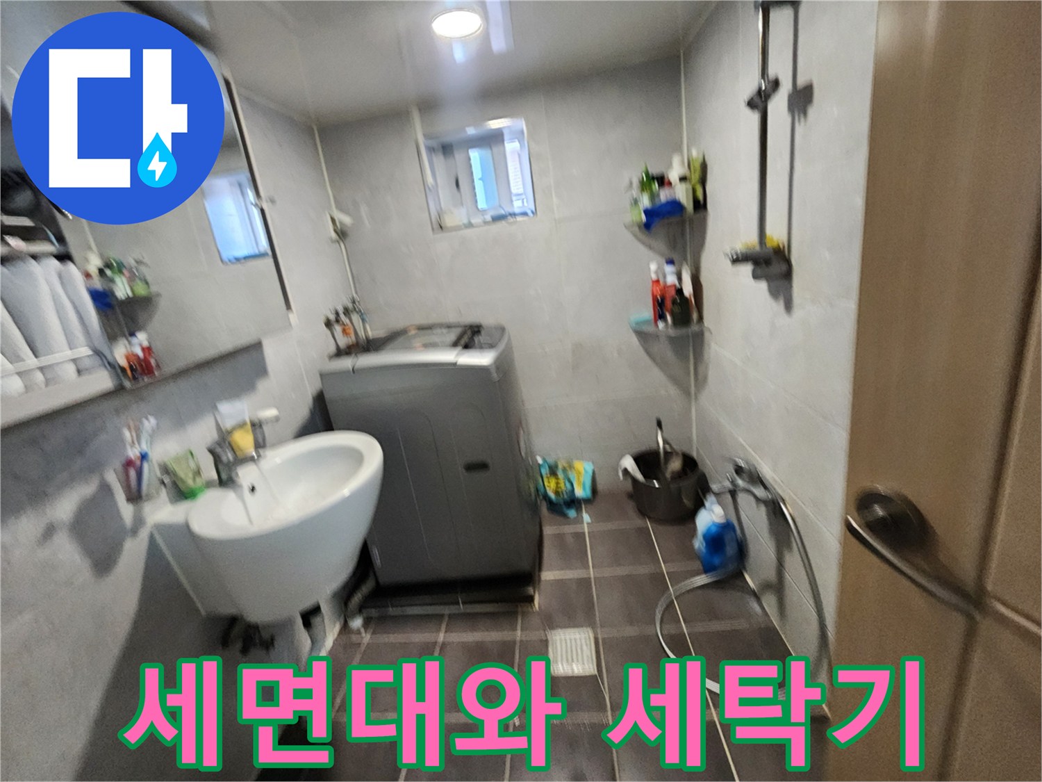 화장실 내부에 설치된 흰색 세면대와 세탁기 주변 공간입니다.