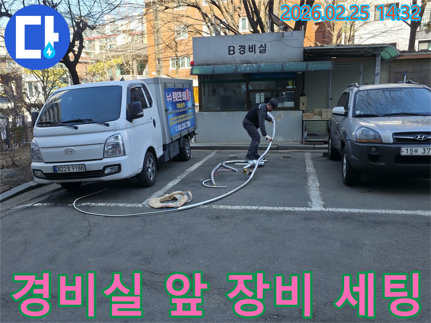 누수 전문 엔지니어가 공동주택 경비실 앞에서-누수 탐지 장비를 세팅하며-정확한 원인 파악을 위해 노력하고 있습니다.