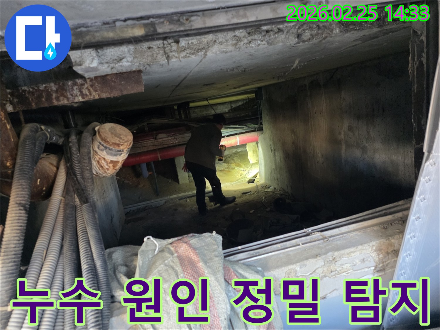 손전등을 든-누수 전문가가-복잡한 배관 사이에서-누수 지점을-확인하는 중