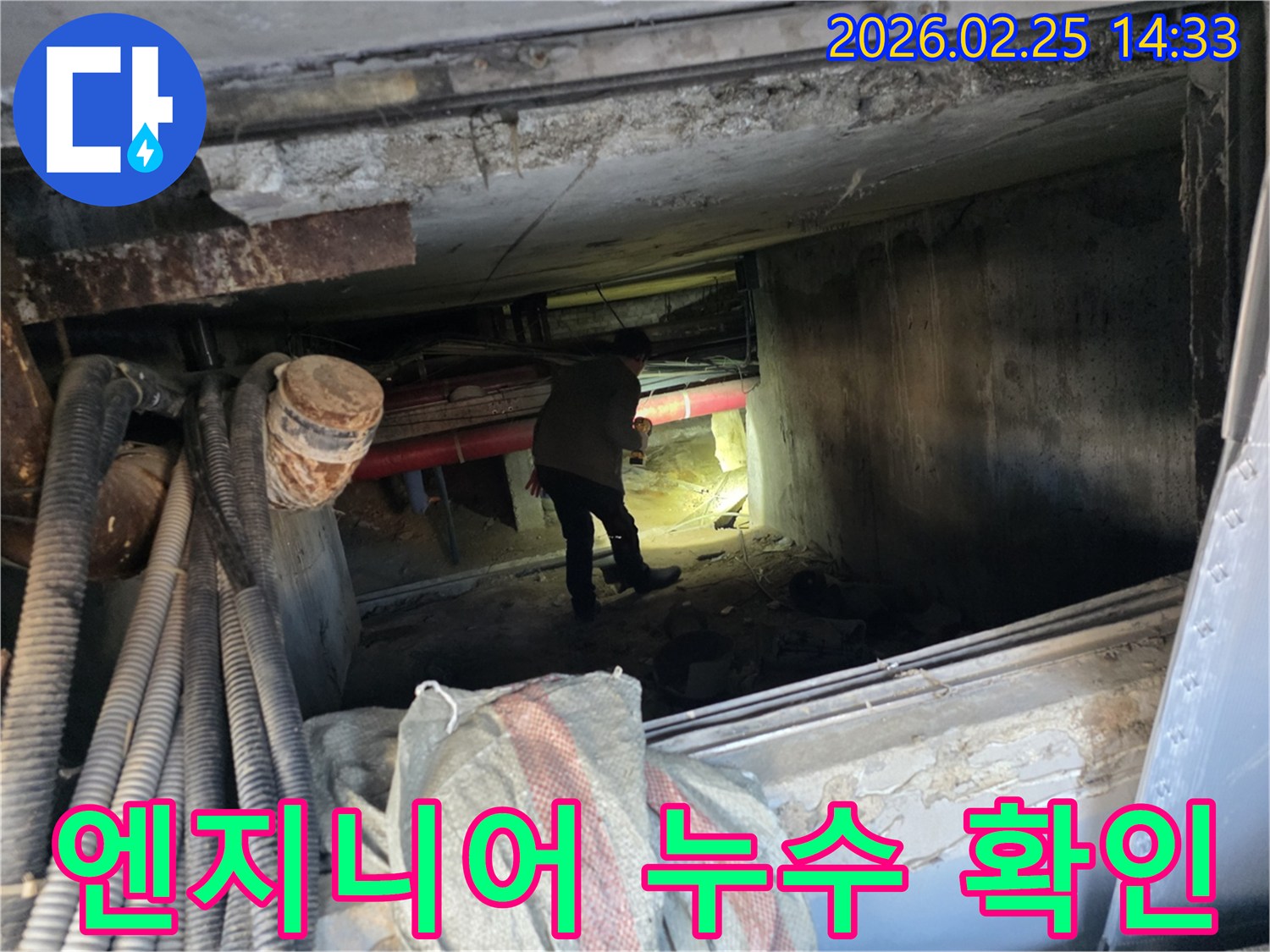 손전등을 든-누수 전문가가-복잡한 배관 사이에서-누수 지점을-확인하는 중