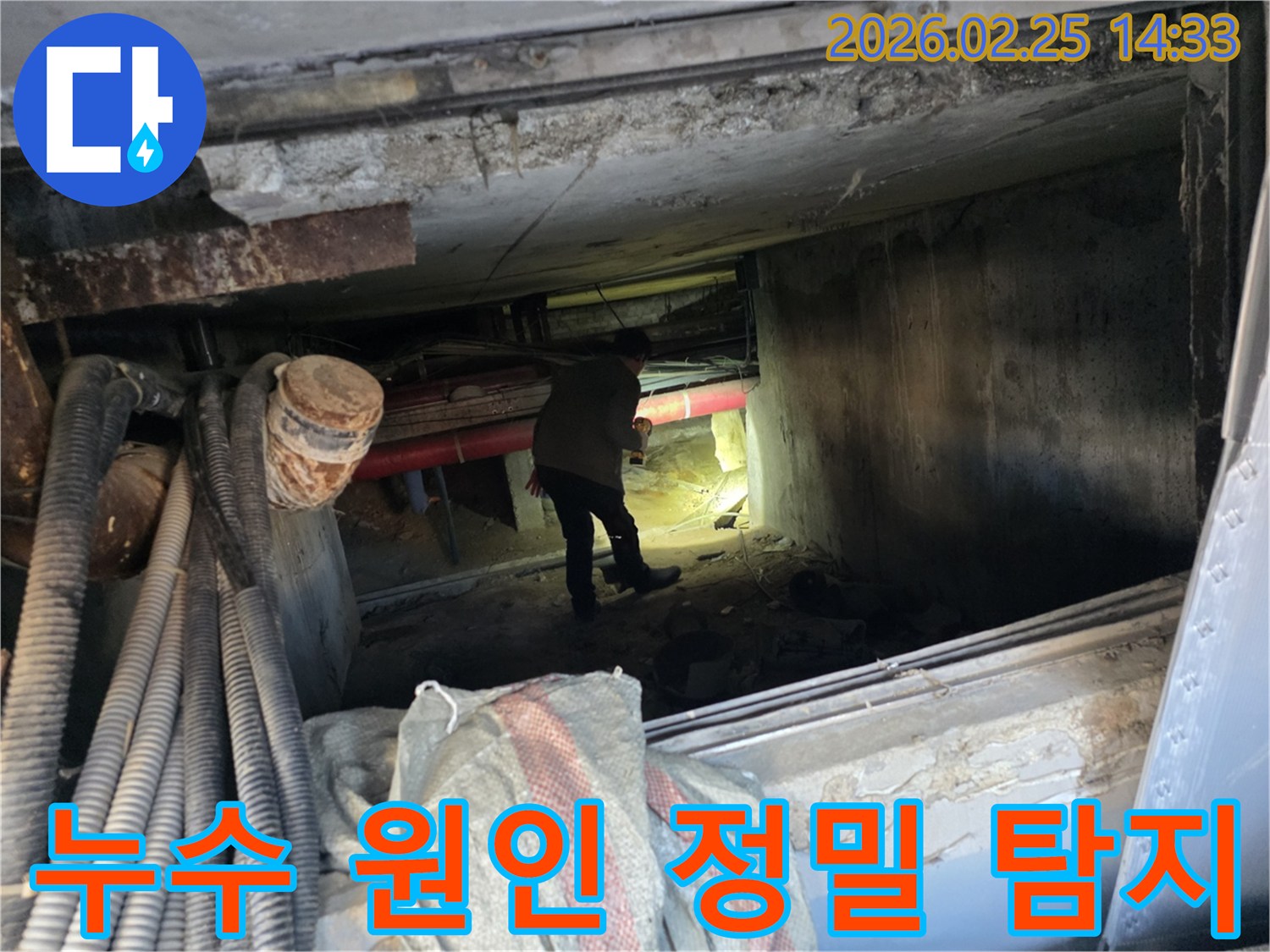 손전등을 든-누수 전문가가-복잡한 배관 사이에서-누수 지점을-확인하는 중