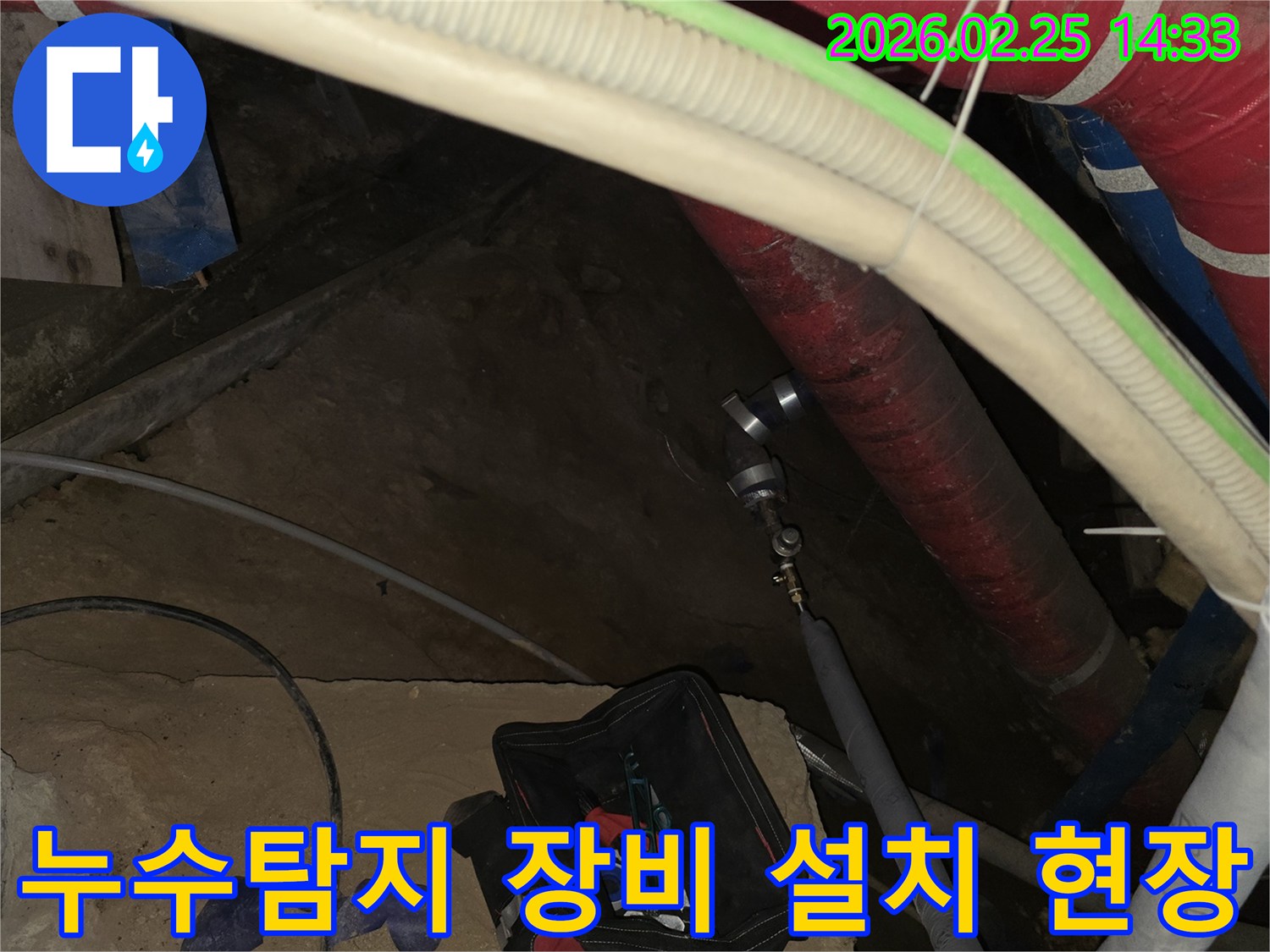 아파트 누수 원인을 파악하기 위해-배관에 정밀 진단 장비를 설치하는-전문가의 손길입니다.