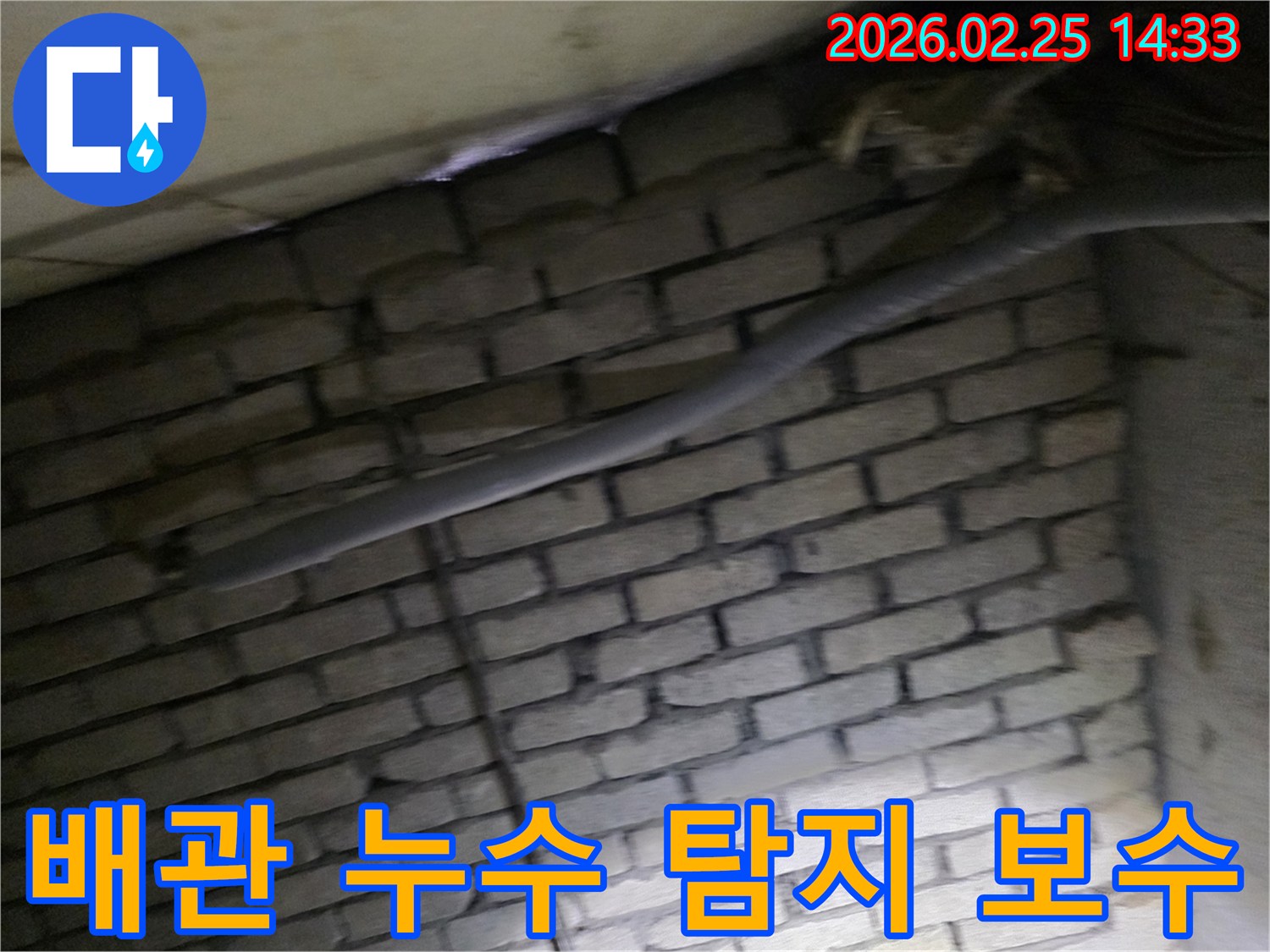 어두운 벽돌 벽면을 배경으로-단열재로 감싸인 배관에서-누수 여부를 탐지하고-보수 작업을 준비하는 현장 이미지입니다.