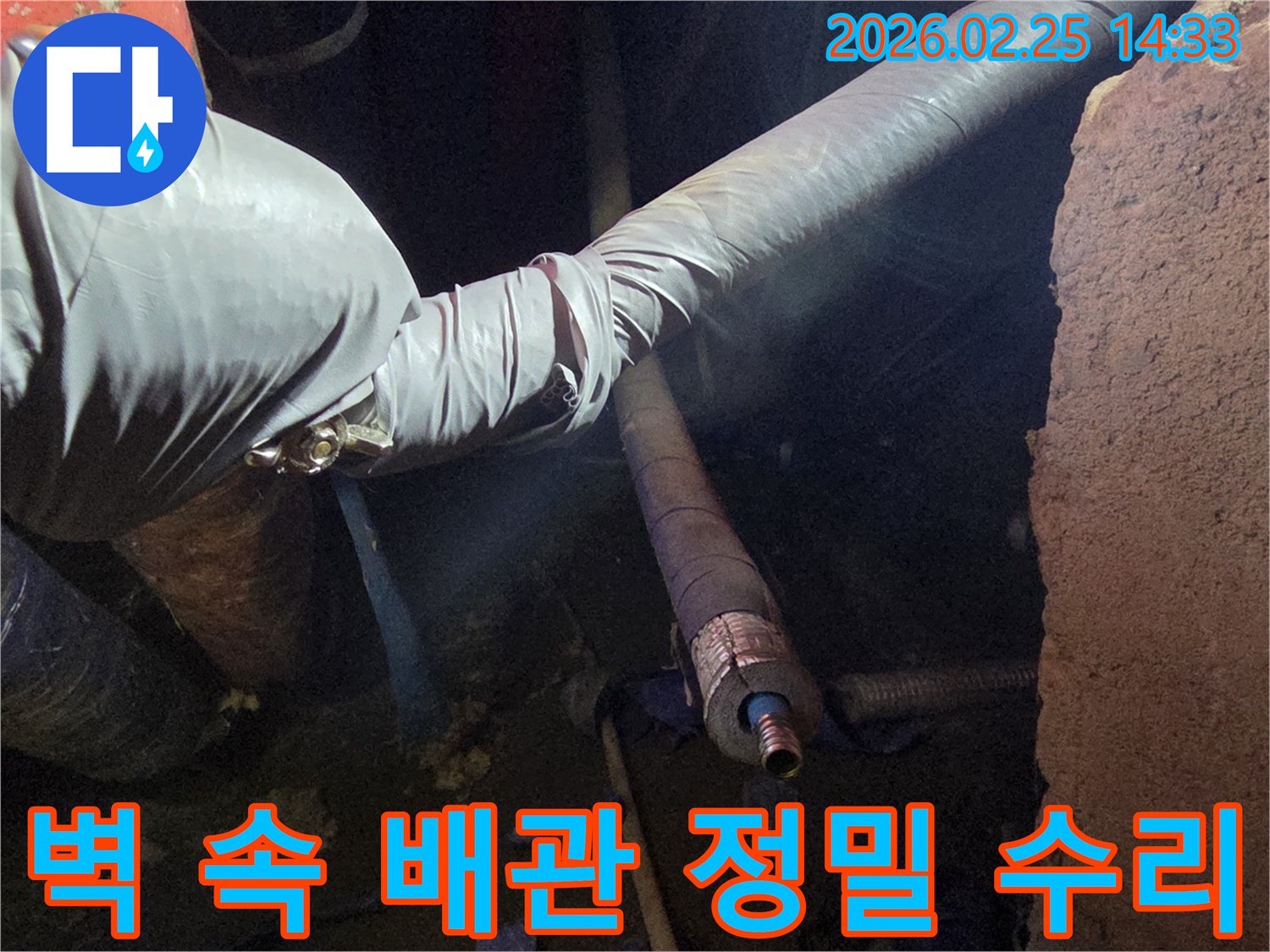 어두운 벽체 내부에서-장갑을 낀 손이-배관의 누수 지점을-최소한의 절개로-정밀하게 수리하는-모습입니다
