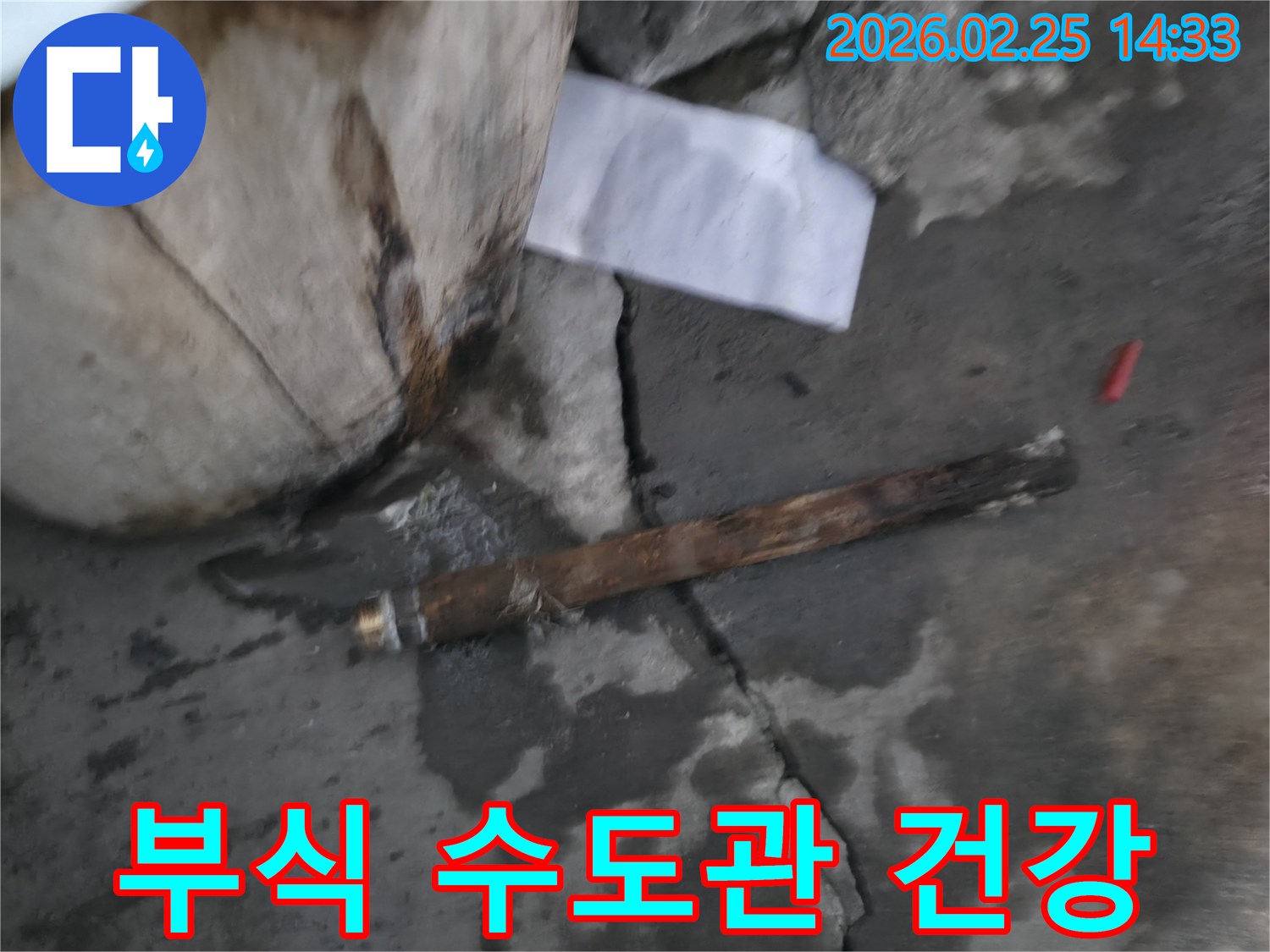 오래되어 부식된-파열된 수도관이-젖은 바닥에 놓여있는-누수 공사 현장 사진입니다.