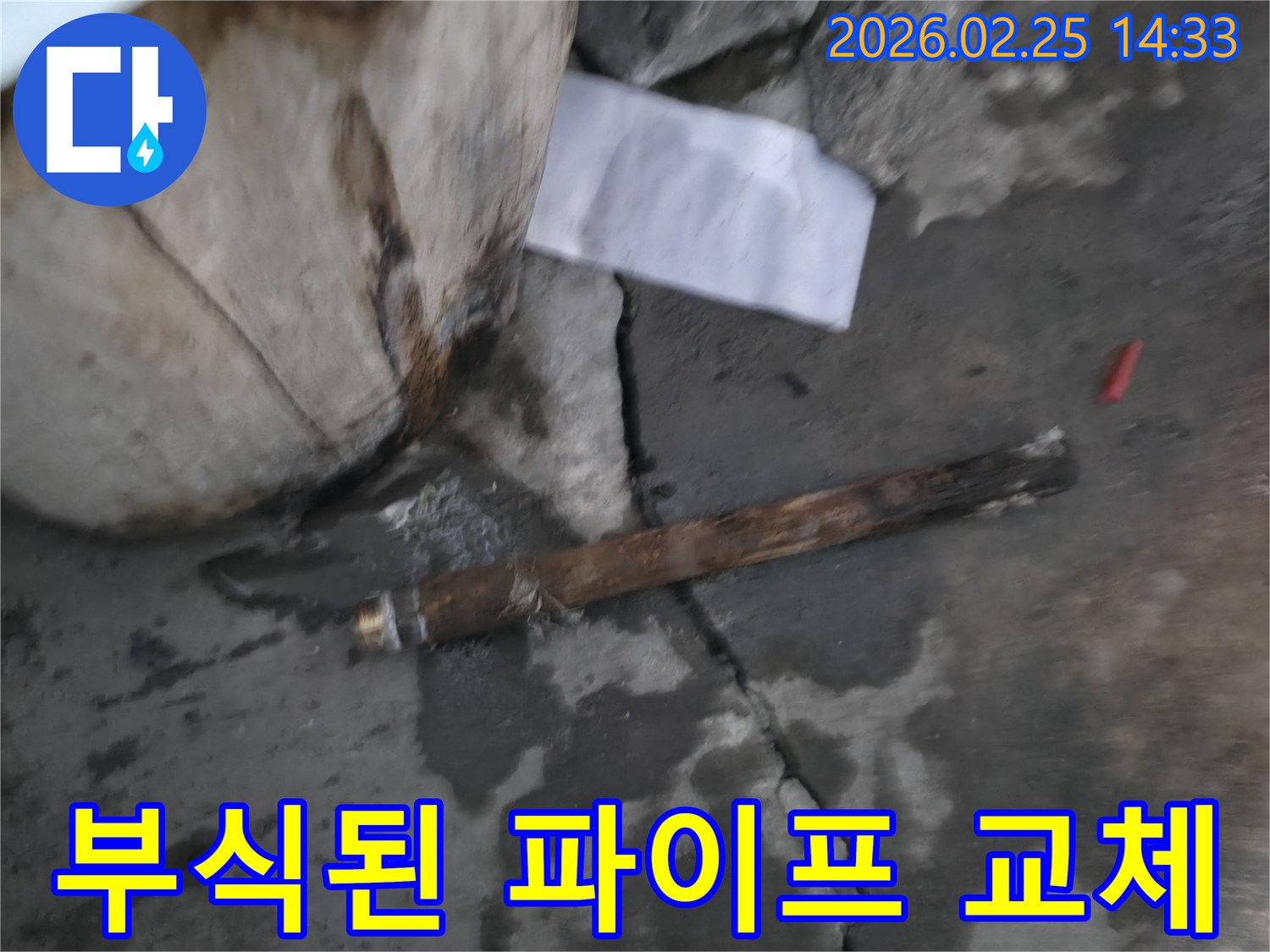 오래되어 부식된-파열된 파이프가-젖은 바닥에 놓여있는-누수 공사 현장 사진입니다.