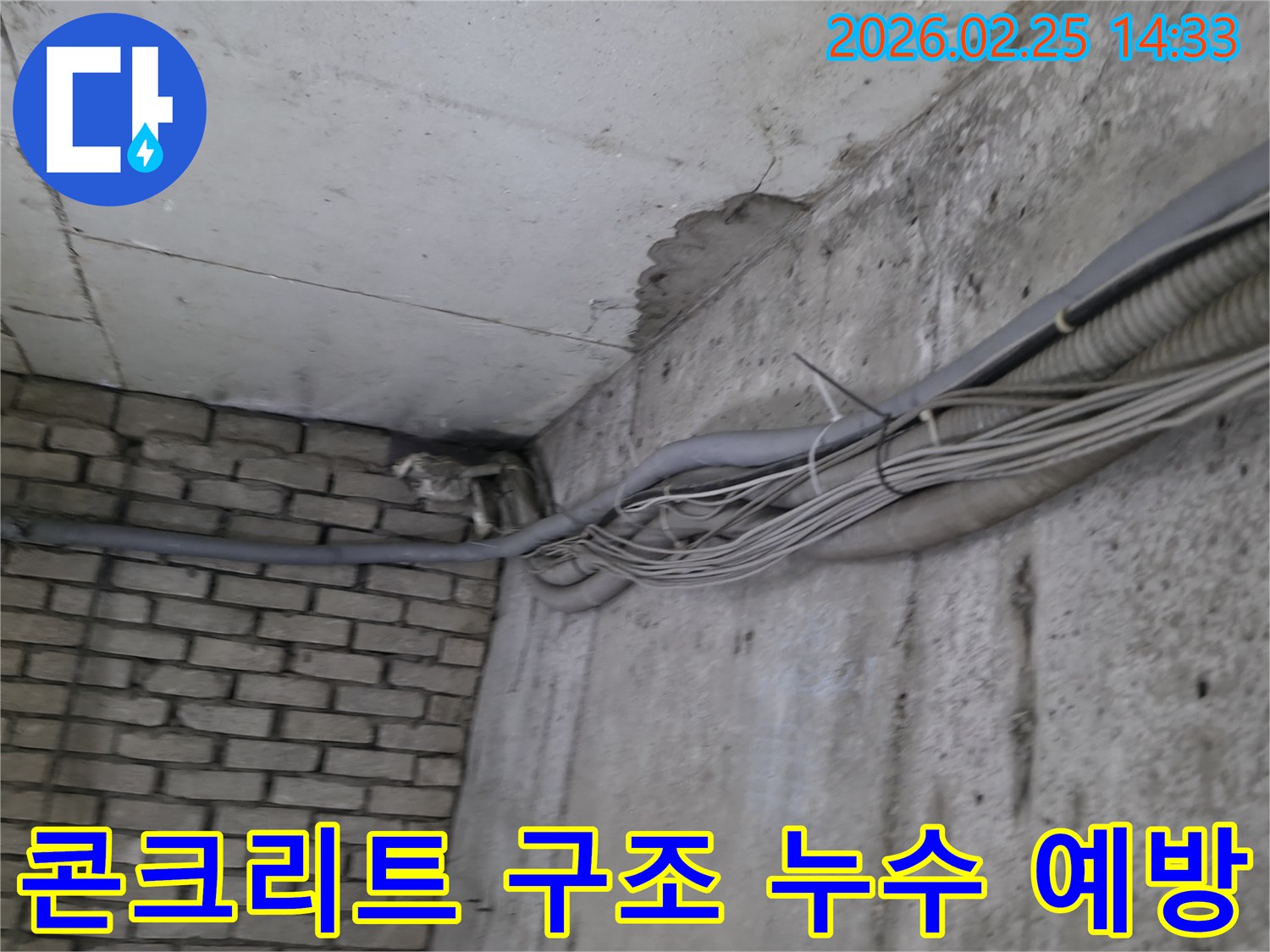 지하 벽면의-콘크리트와-벽돌 벽이 만나는-지점에서-발견된-오랜 누수로 인한-물자국과-주변의 복잡한 배관