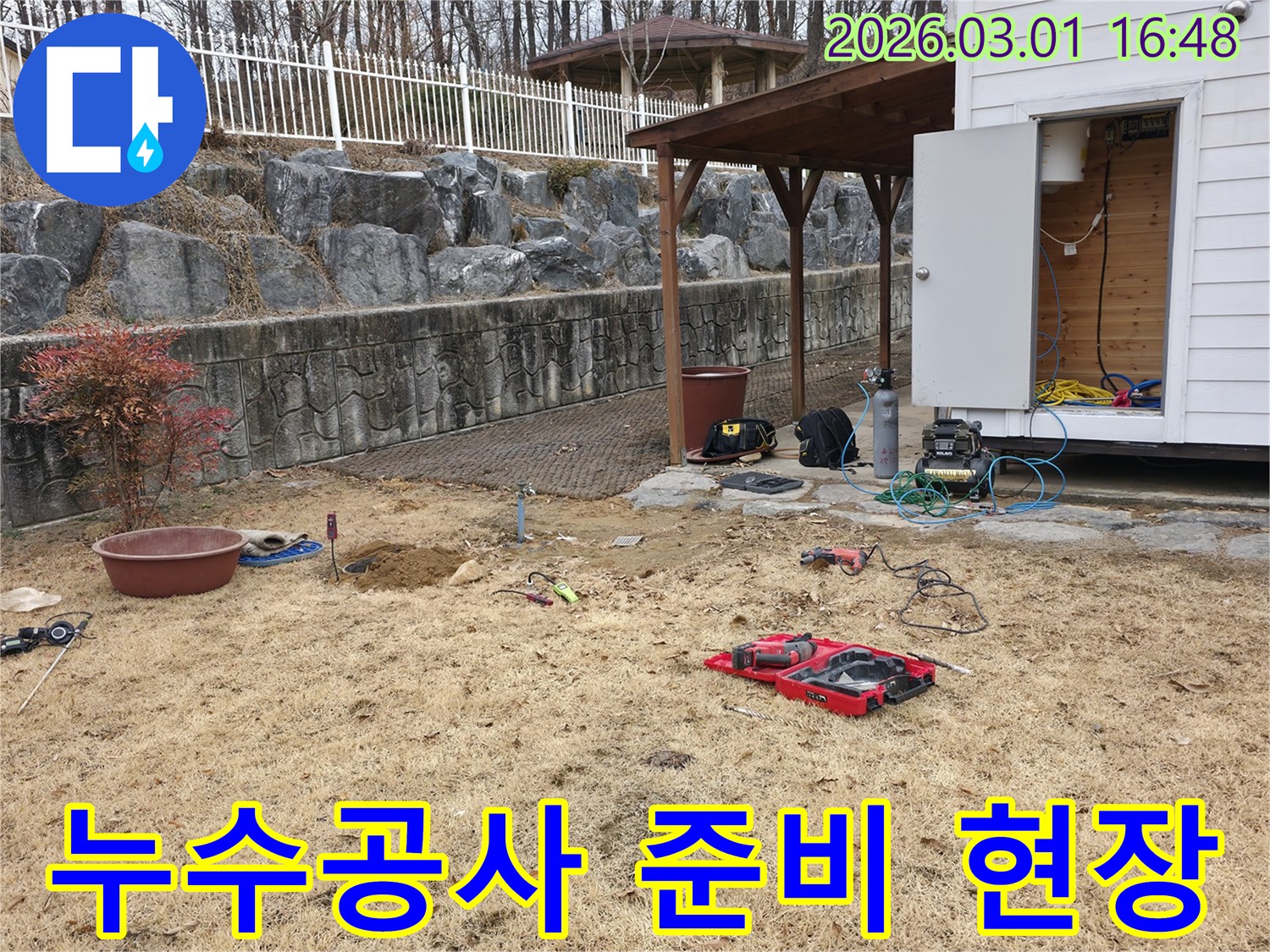 야외-마당에서-누수-공사를-위한-준비-작업이-진행-중인-전경을-보여줍니다.