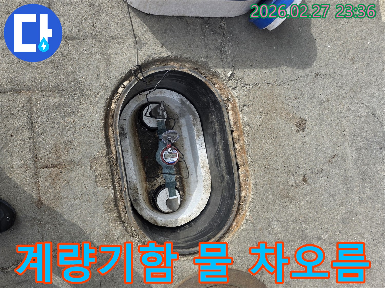 지하에 매설된 수도 계량기함 내부에-물이 차오른 상태를 보여주는 사진입니다.