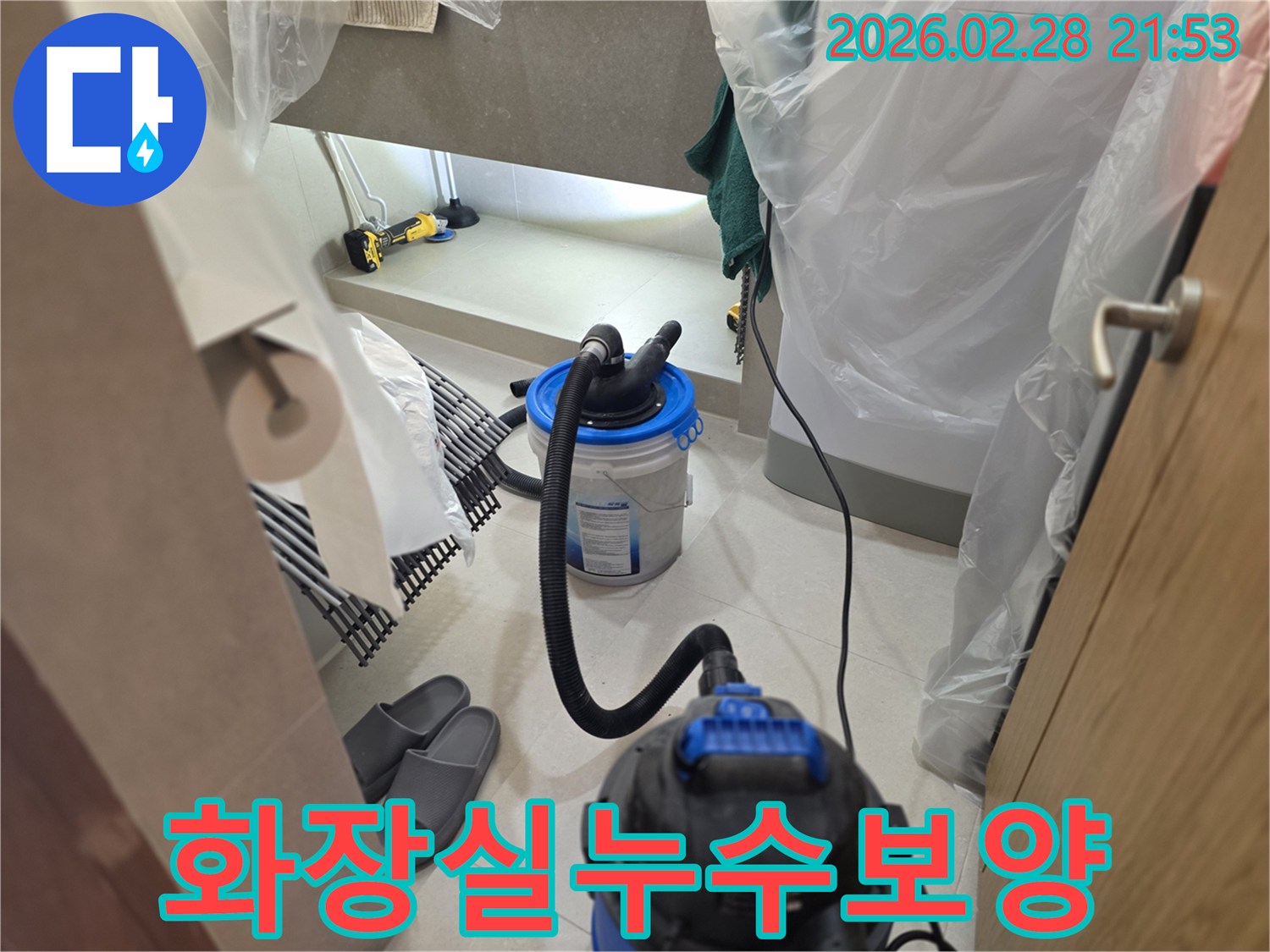 이 이미지는 화장실 누수 탐지 시-주변 가구를 보호하기 위한 보양 작업과-습식 청소 장비를 설치한 모습입니다.