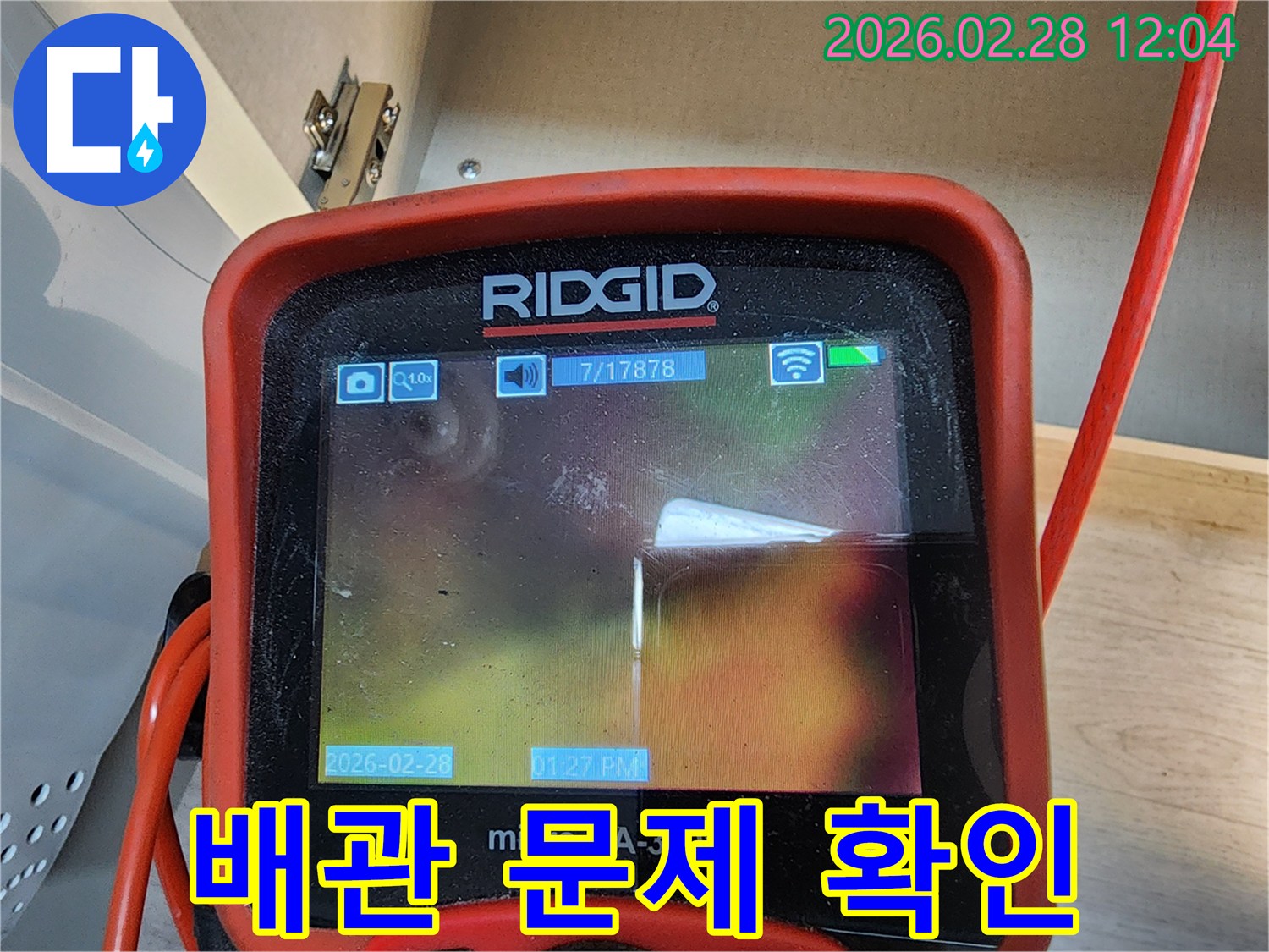 누수 엔지니어가-고성능 리지드 내시경 카메라를 사용하여-상가 바닥 아래의 배관 내부를-정밀하게 검사하고-누수 원인을 파악하는-모습입니다.