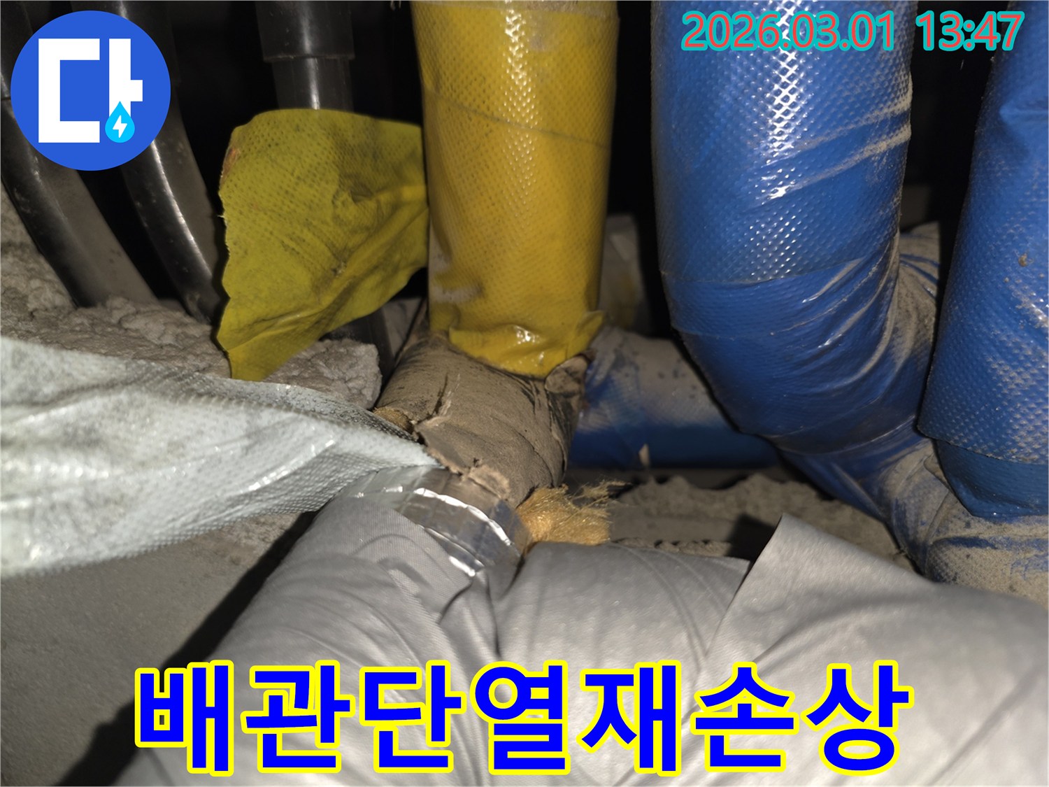오래된 배관의 단열재가 심하게 손상되어-내부 배관이 노출된 현장 사진입니다.