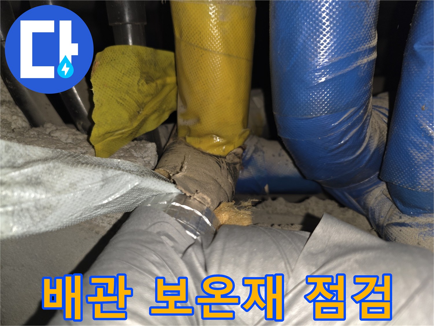 파란색과 노란색 보온재로 감싸진 배관의 상태를 확인하는 모습입니다.