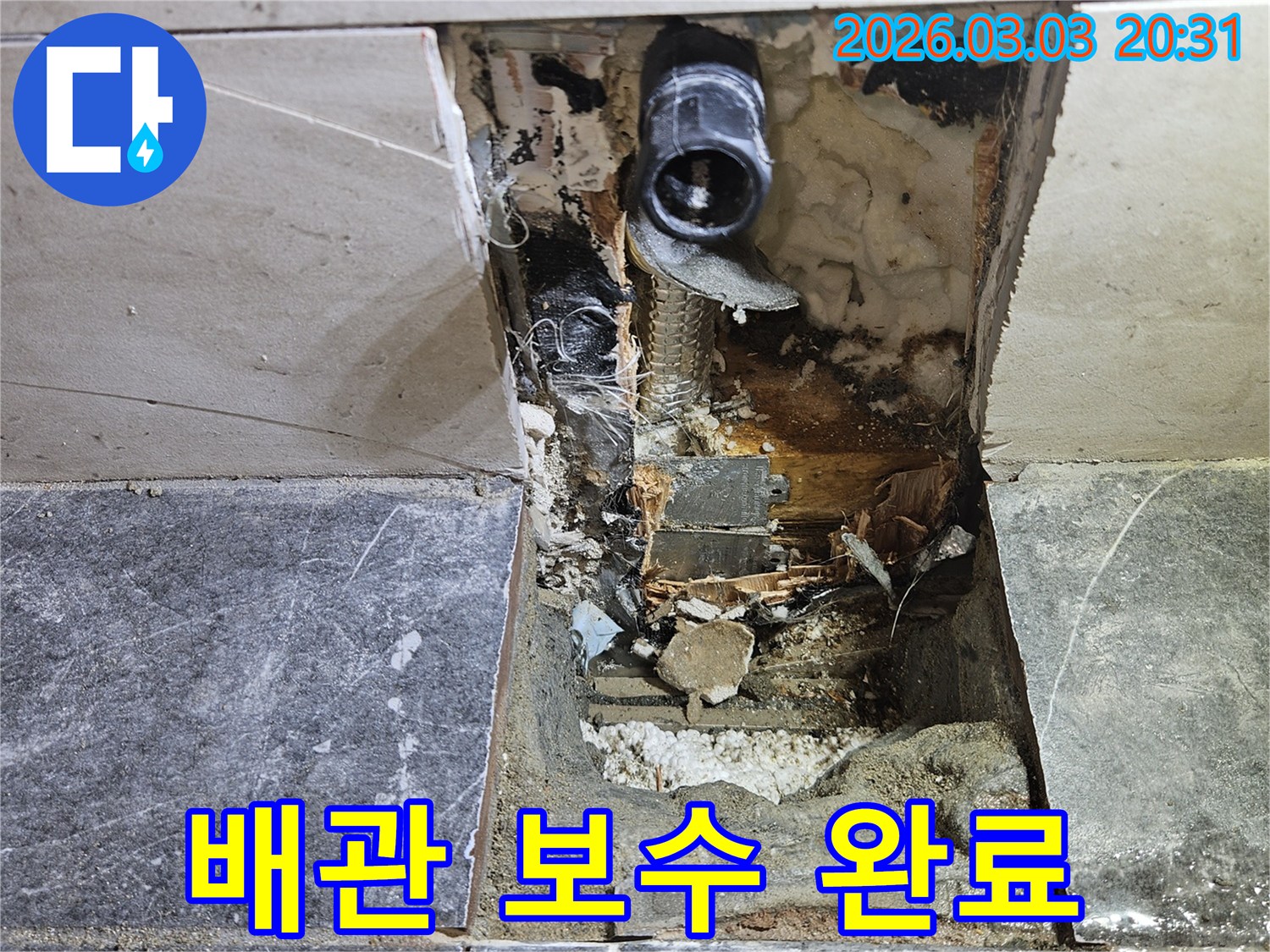 벽면 타일이 제거된 후-누수 원인이었던 배관의 보수 작업이 완료되고-주변 정리가 진행 중인 현장 모습
