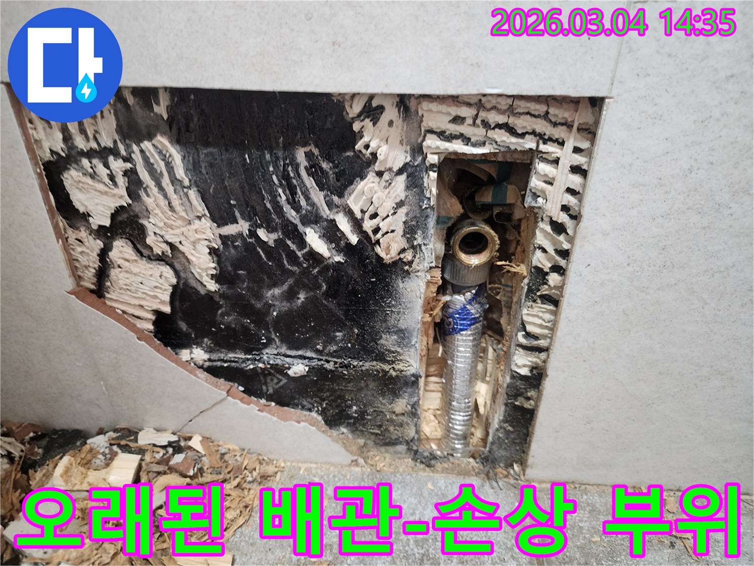 오래된-주택에서-발생한-누수로-인해-벽면을-뜯어낸-후-드러난-손상된-배관의-상태를-보여주는-이미지