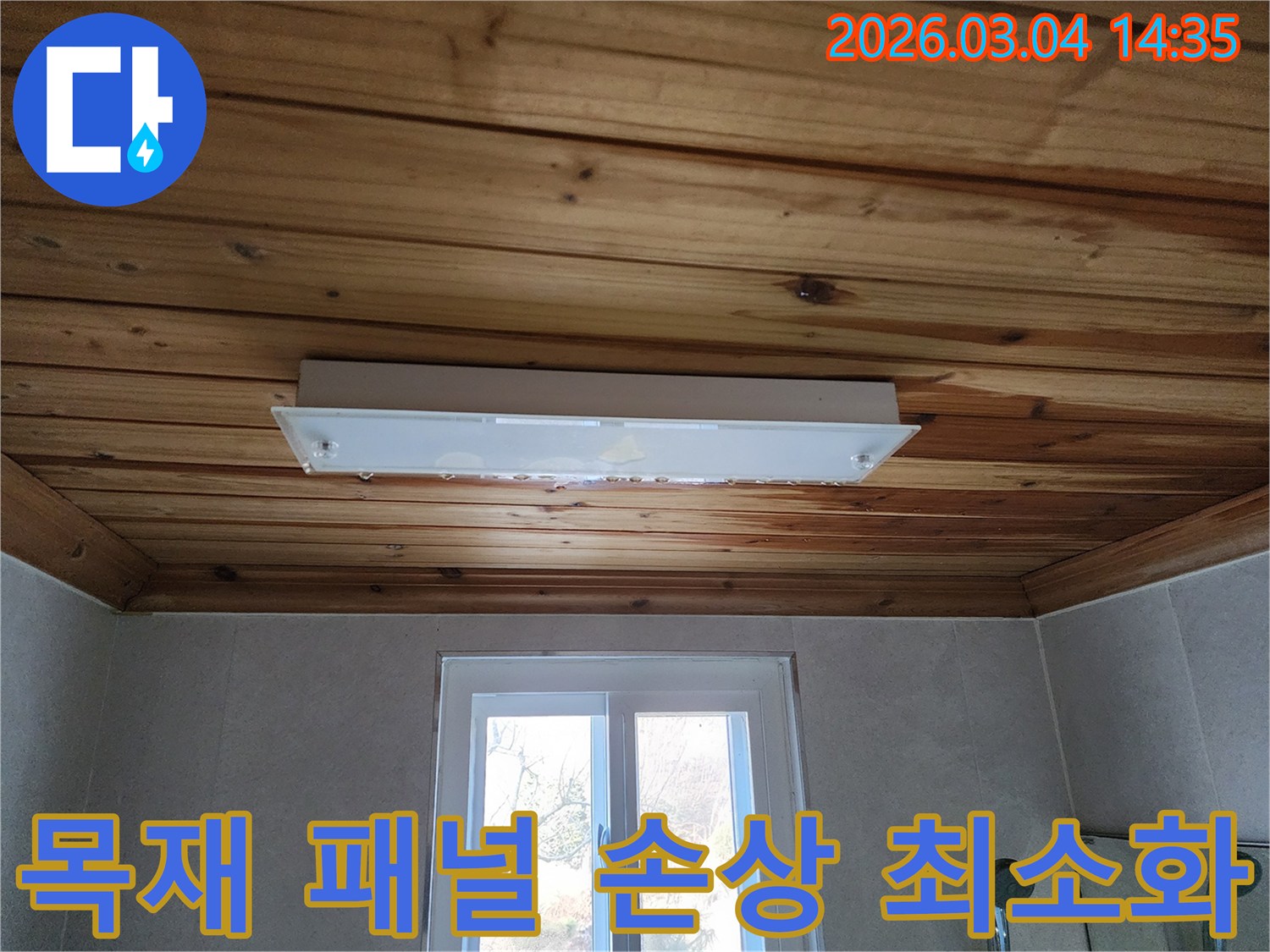 천장 등기구에서 물이 떨어지는 모습으로-목재 천장에도 물자국이 선명한-누수 현장의 심각성을 보여주는 사진입니다.