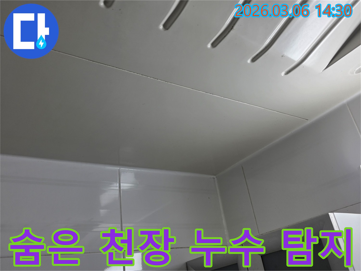 겉보기에는-깨끗한-천장-패널-아래에-숨겨진-누수-가능성을-탐지하는-전문가의-모습을-담은-사진입니다.