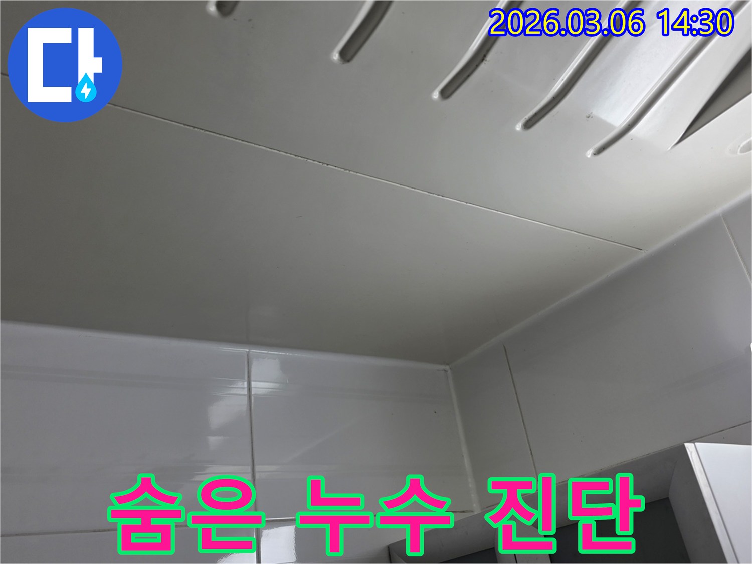 겉으로는-깨끗해-보이지만-잠재적인-누수-가능성을-확인하기-위해-천장-패널을-정밀-진단하는-전문가의-모습을-담은-이미지입니다.
