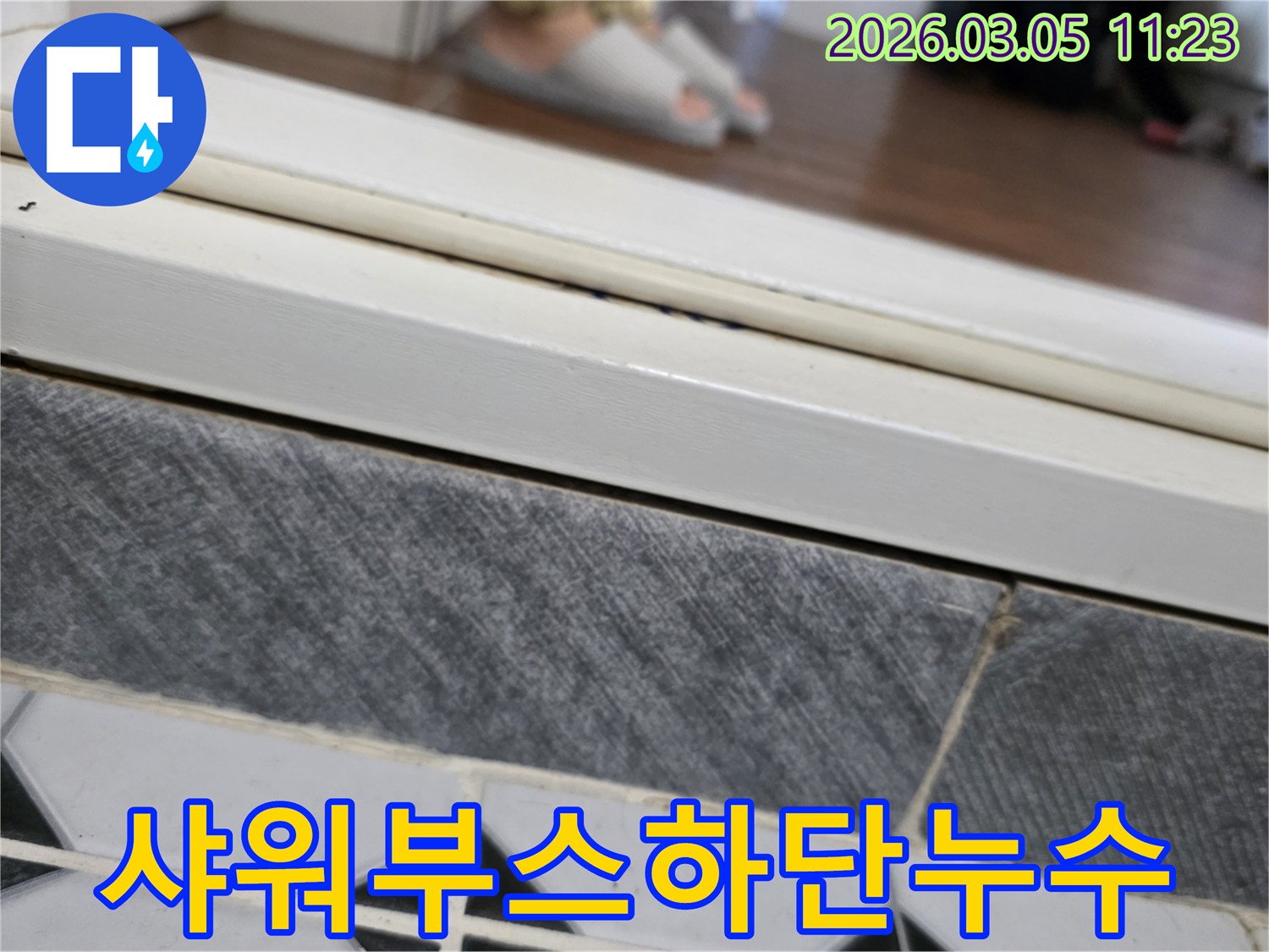 전문-누수-탐지사가-샤워부스-하단-타일-이음새-부분의-물-스며듦-현상을-진단하는-이미지입니다