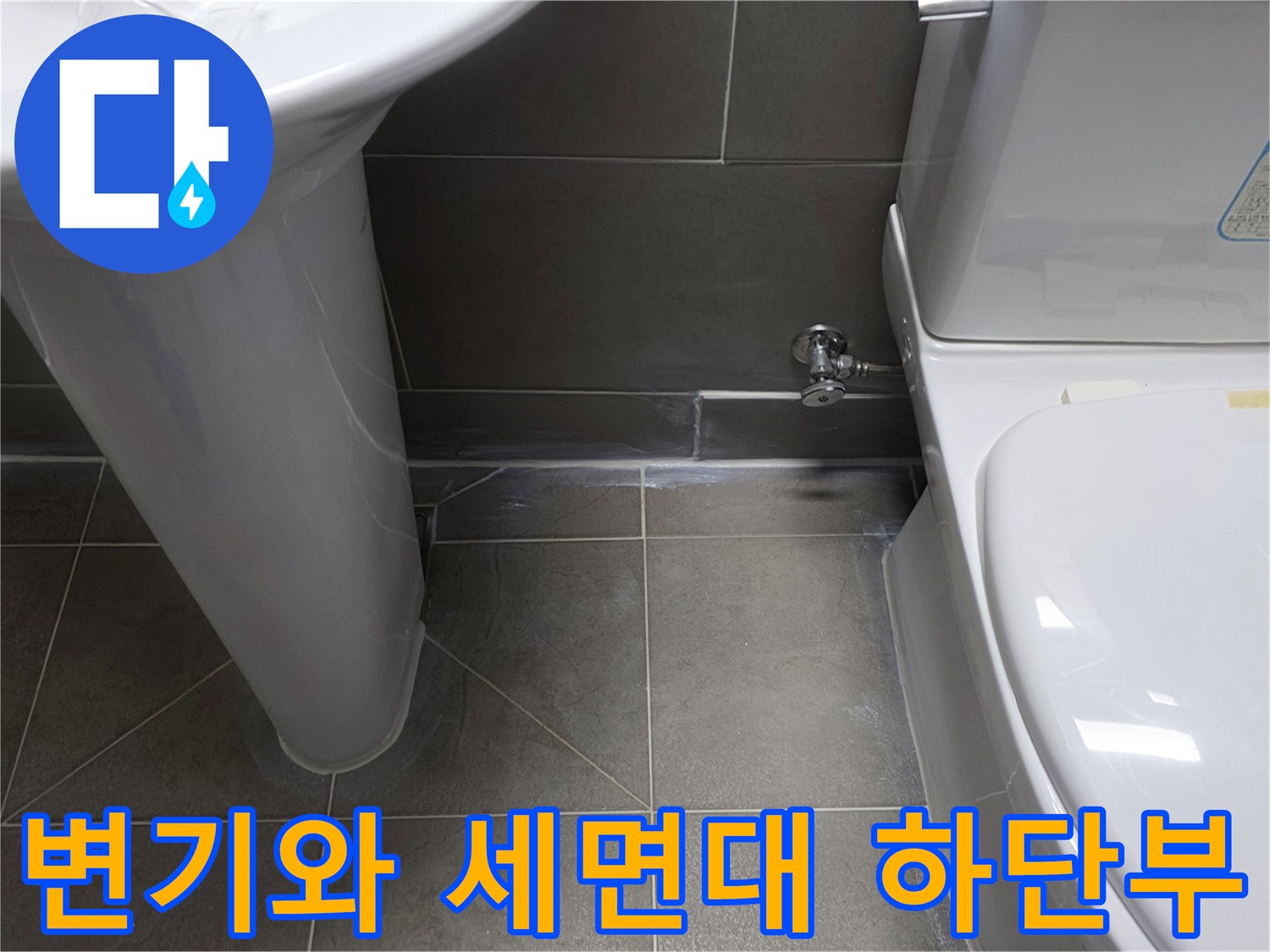 화장실 변기와 세면대 주변의 타일 마감 상태 사진