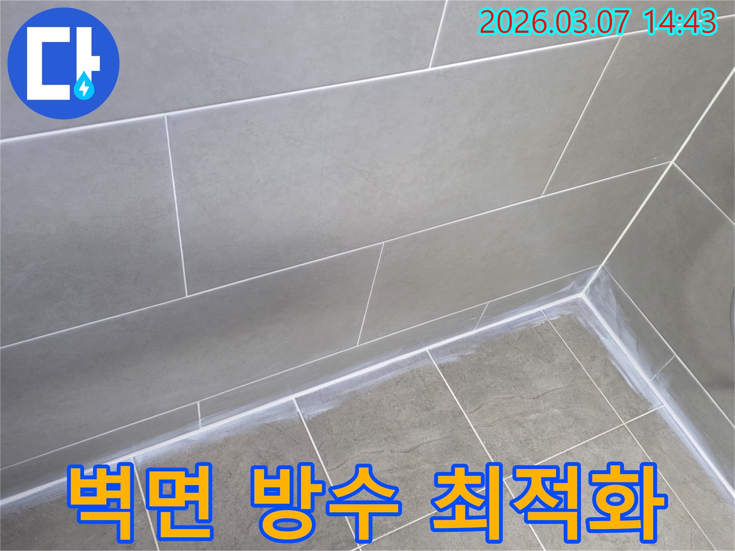 회색 타일로 된-주택 욕실의-벽과 바닥 접합부를-새로운 실리콘으로-튼튼하게 마감하여-벽면 방수 성능을 최적화한 사진