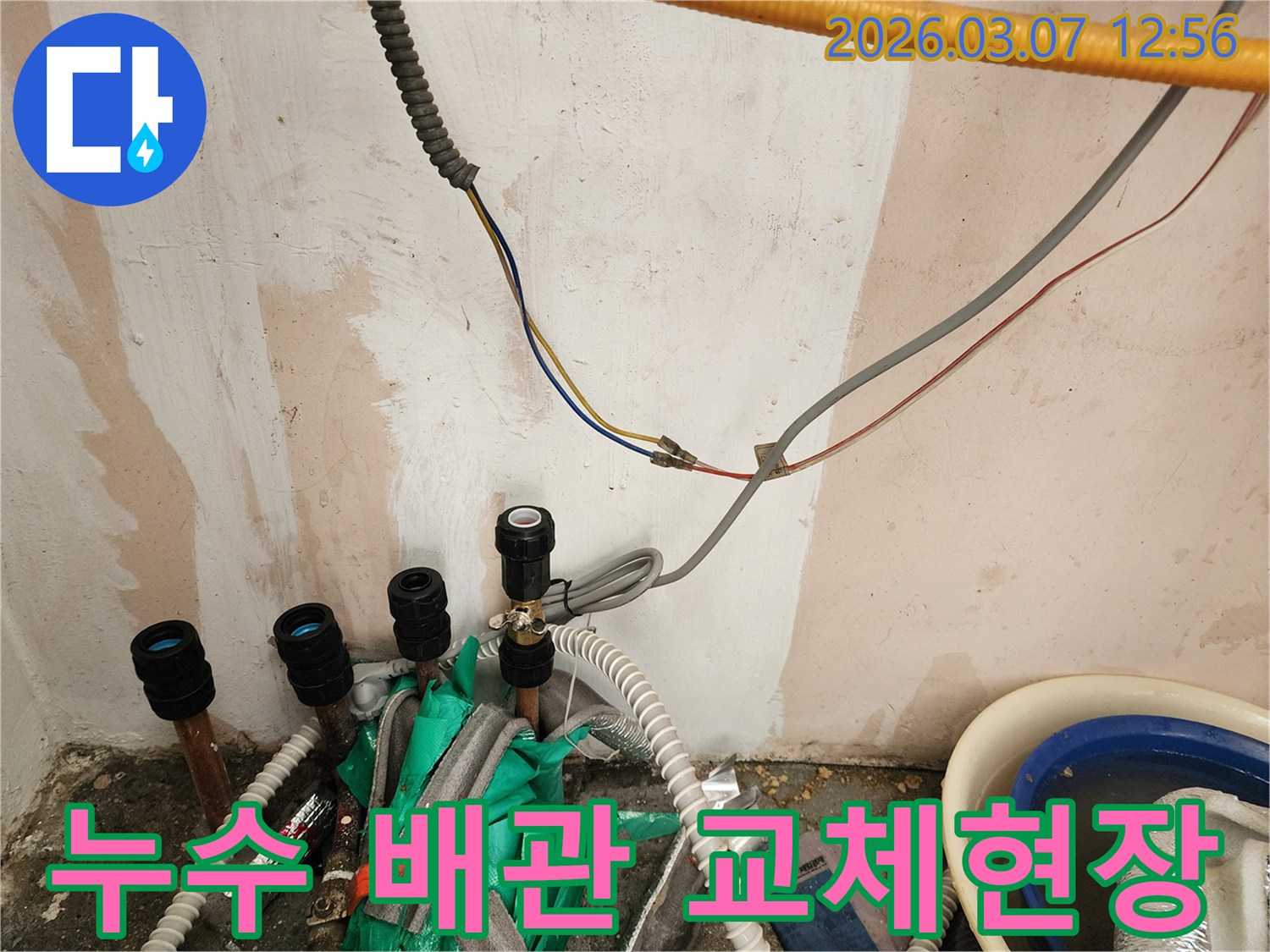누수 복구 공사 중-손상된 배관을 교체하기 위해-현장을 정리하는-작업자의 모습입니다