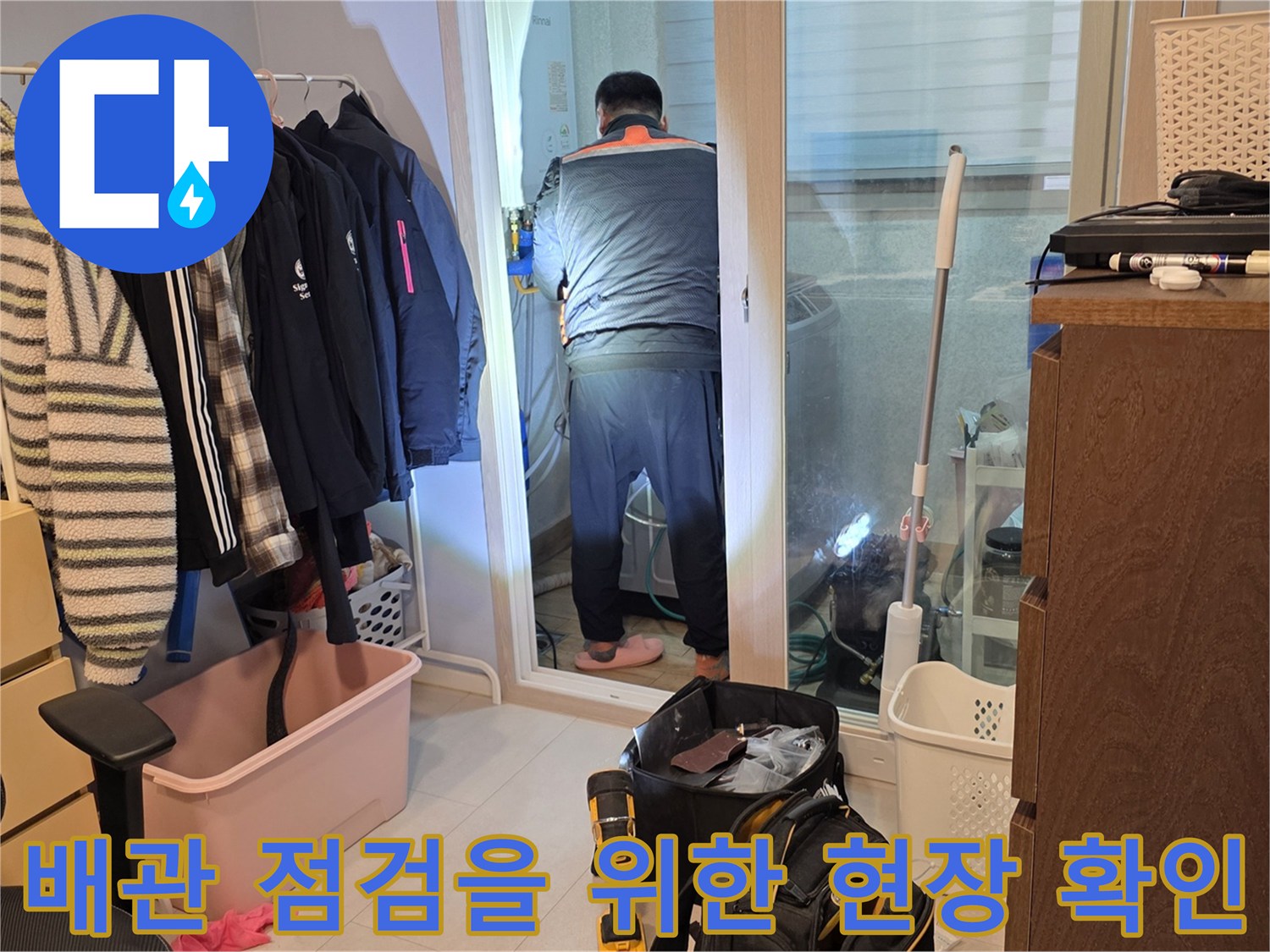 베란다 내부 공간에서 배관 누수 여부를 판단하기 위해 작업자가 점검 중입니다.