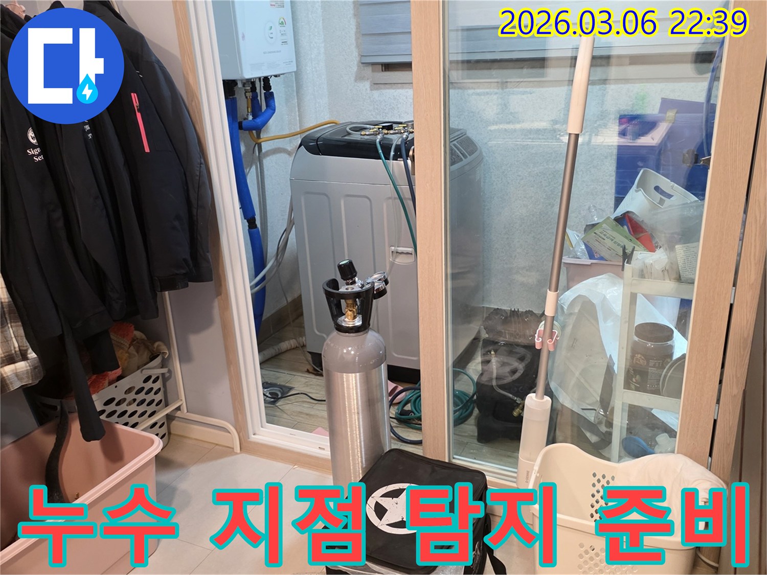 세탁실에서-누수 지점을 정확히 찾기 위해-가스 탐지 장비를-신중하게 연결하는 모습입니다