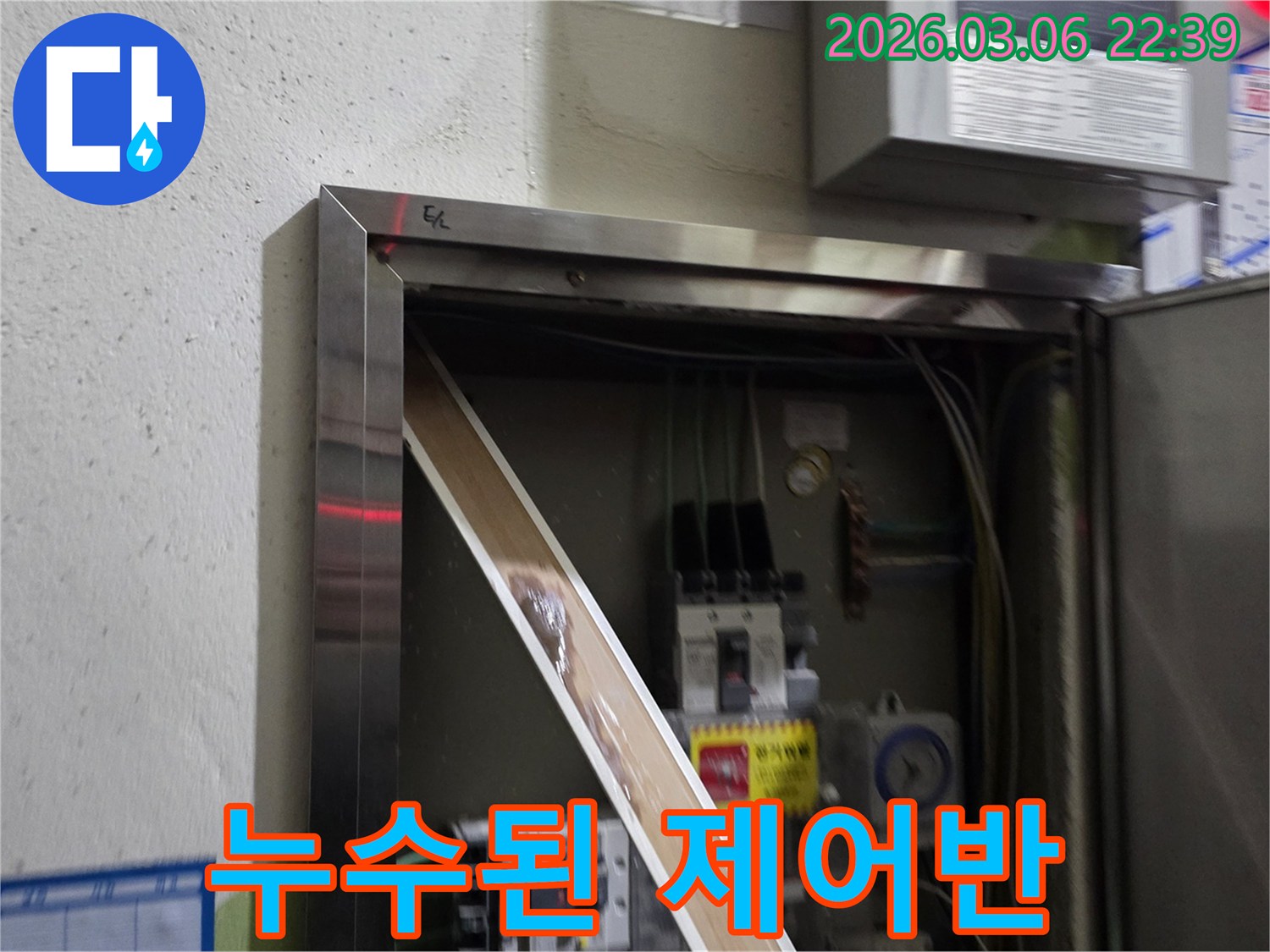 이 이미지는 전기 제어반 내부에서 발견된 심각한 누수 흔적을-보여주며-전기 안전에 대한 위험을-경고합니다.
