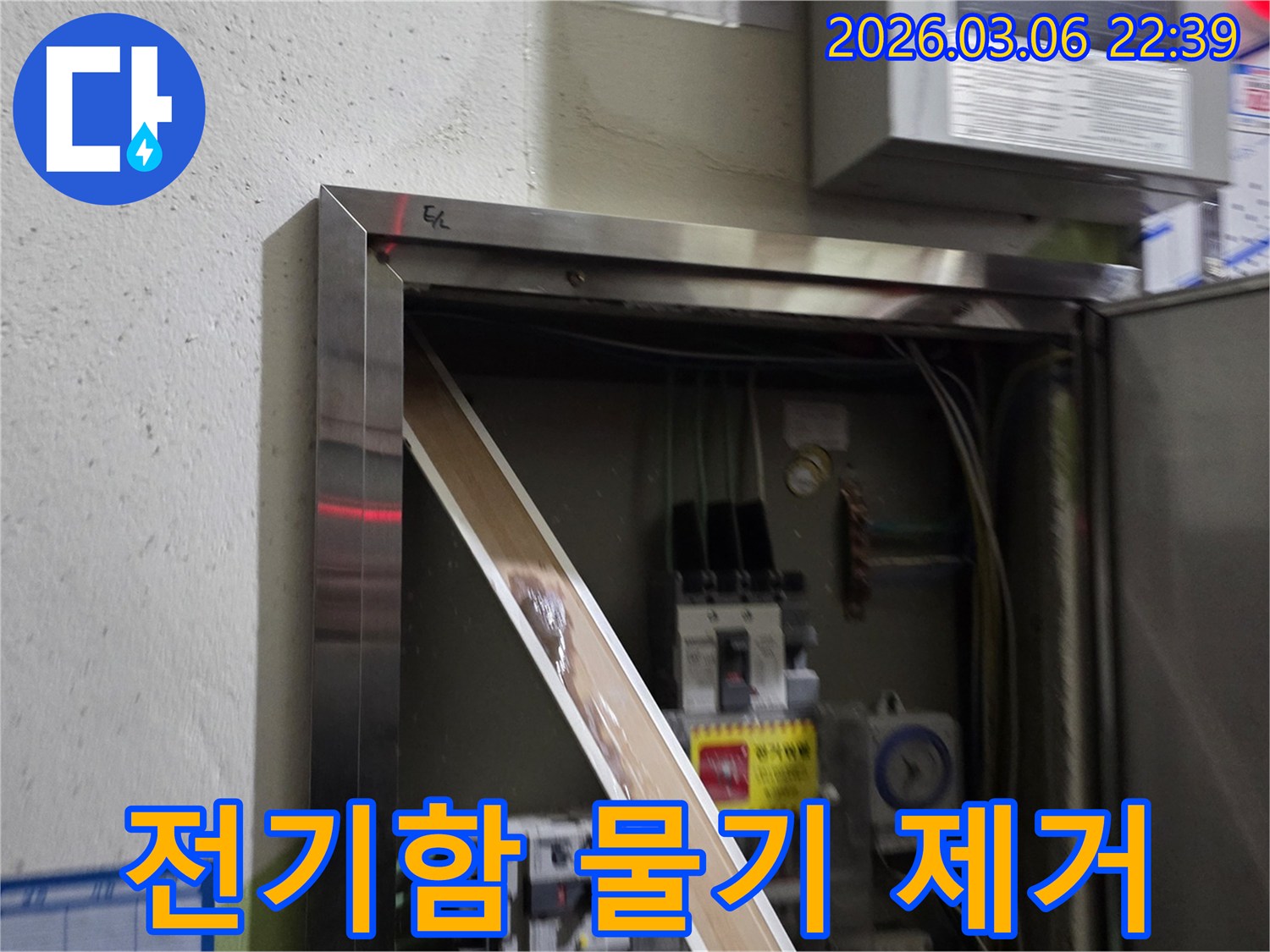 이 이미지는 전기함 내부로 유입된 물기를-제거하고 있는 현장을 보여주며-안전한 전기 사용을 위한-복구 작업의 중요성을 강조합니다.