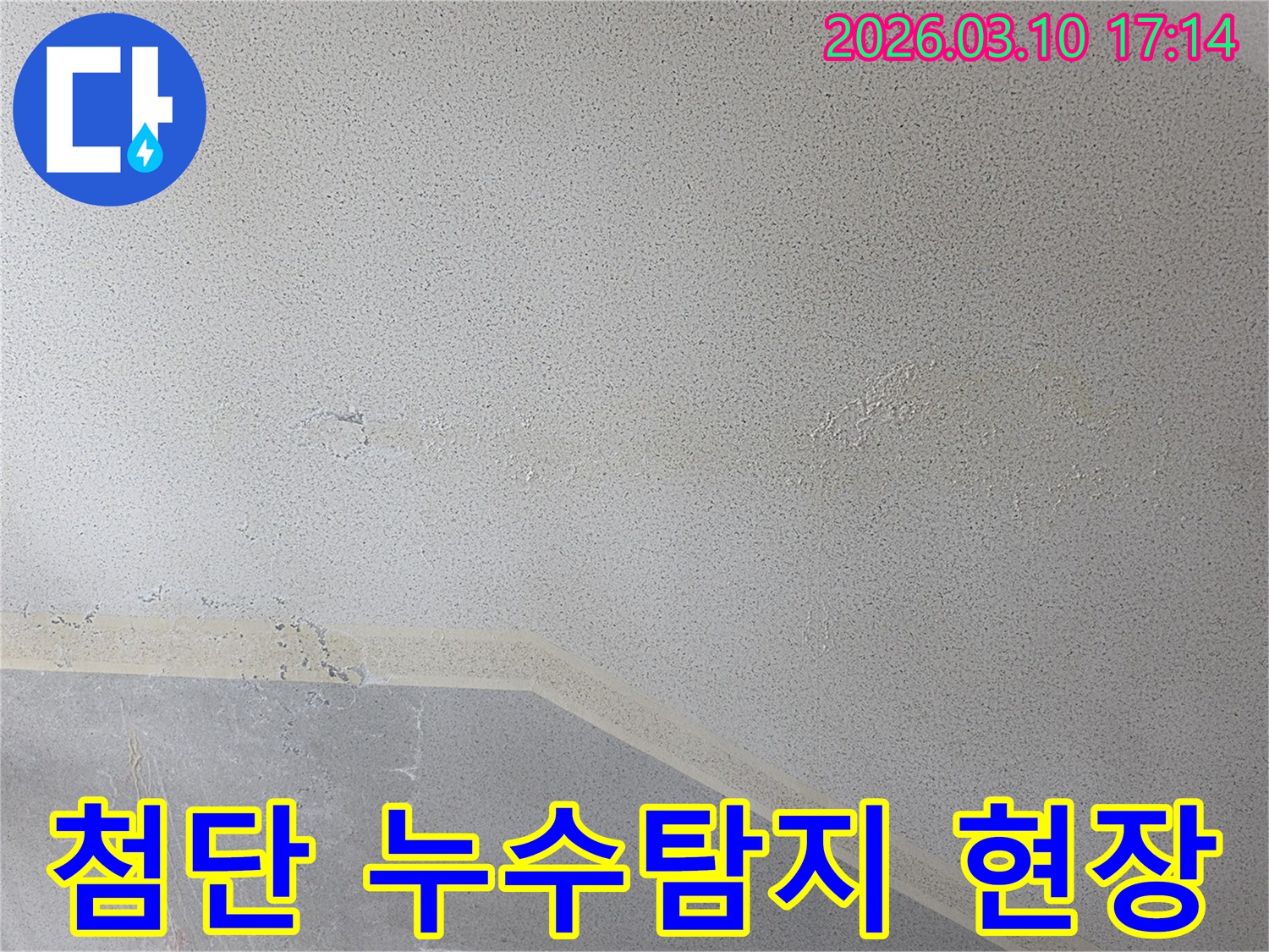 천장에 나타난 누수 흔적은-물이 스며들어 마감재가 손상되고-변색된 상태를 보여주며-첨단 장비를 이용한 정밀 탐지가 필요함을 나타냅니다.