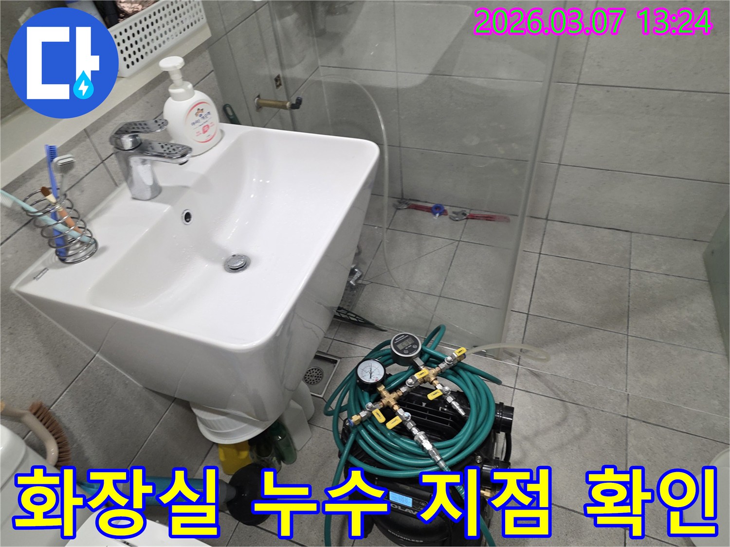 오곡동-화장실에서 누수 탐지 장비를 연결하여-배관 압력 변화를 통해 누수 지점을 감지하는 모습