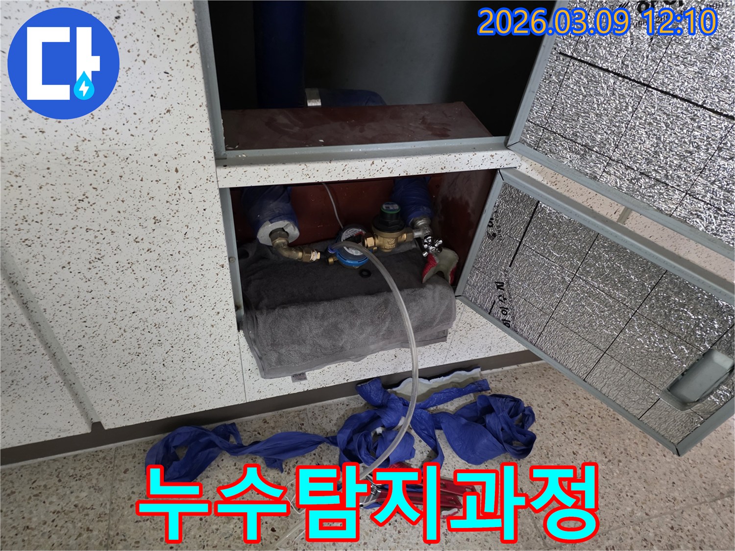 누수-탐지-과정에서-배관에-연결된-측정-장비와-주변-작업-도구들이-보이는-현장입니다